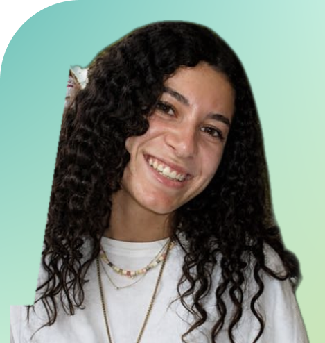 Young woman with dark brown hair smiling, wearing a white shirt and two necklaces, against a light green background.