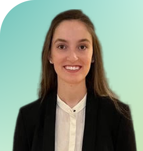 Young woman smiling with black blazer and white button up shirt and brown hair against a green background.