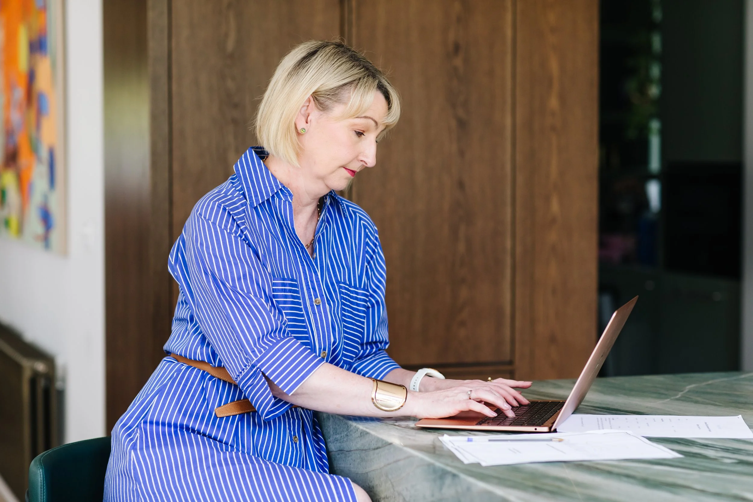Melbourne personal stylist Lorna Woodcock works on laptop reviewing client notes and styling plans at desk, preparing personalised recommendations at Styled for Life.