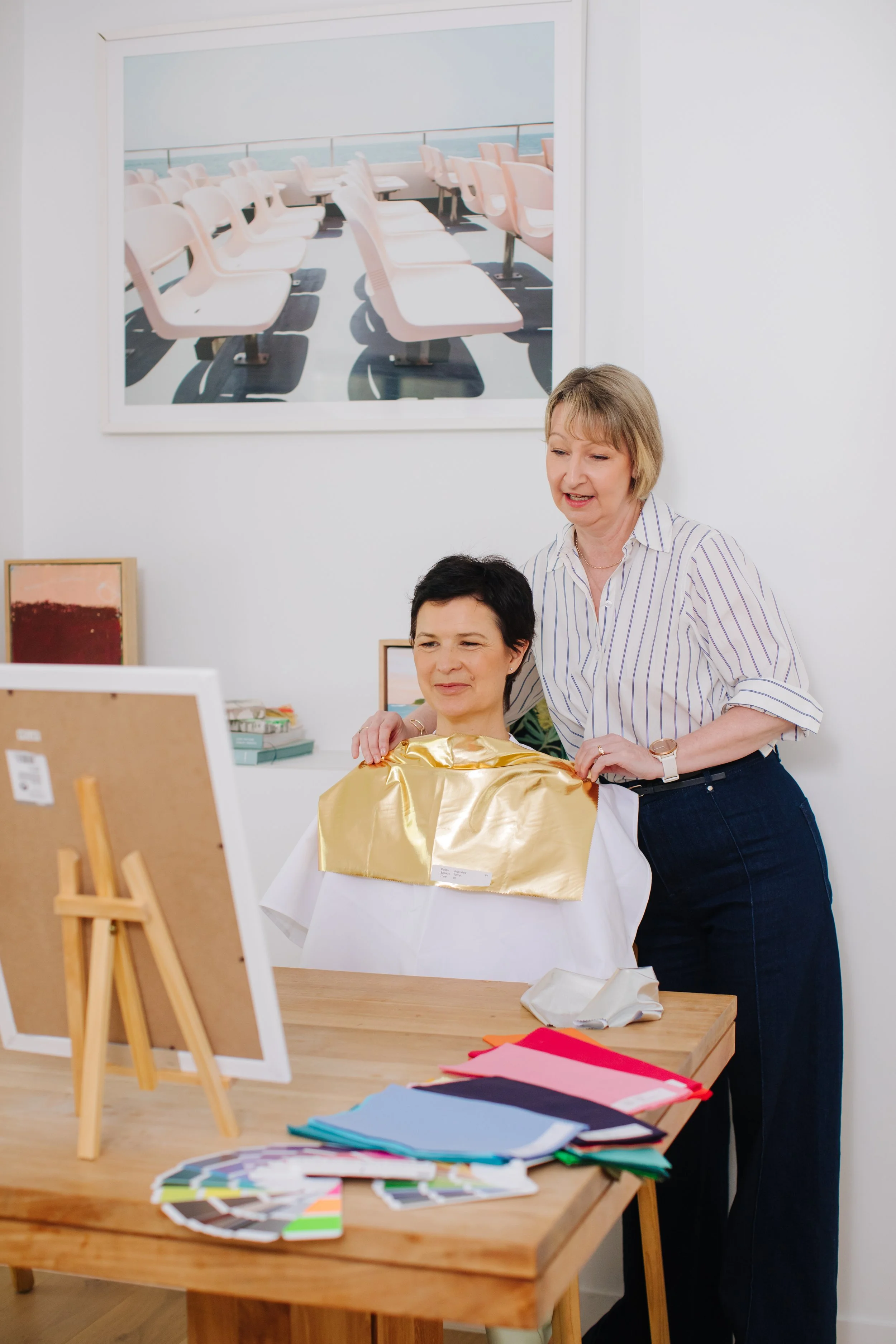 Melbourne personal stylist Lorna Woodcock conducts colour analysis using gold drape on client, assessing skin tone and undertone in studio with fabric swatches at Styled for Life.