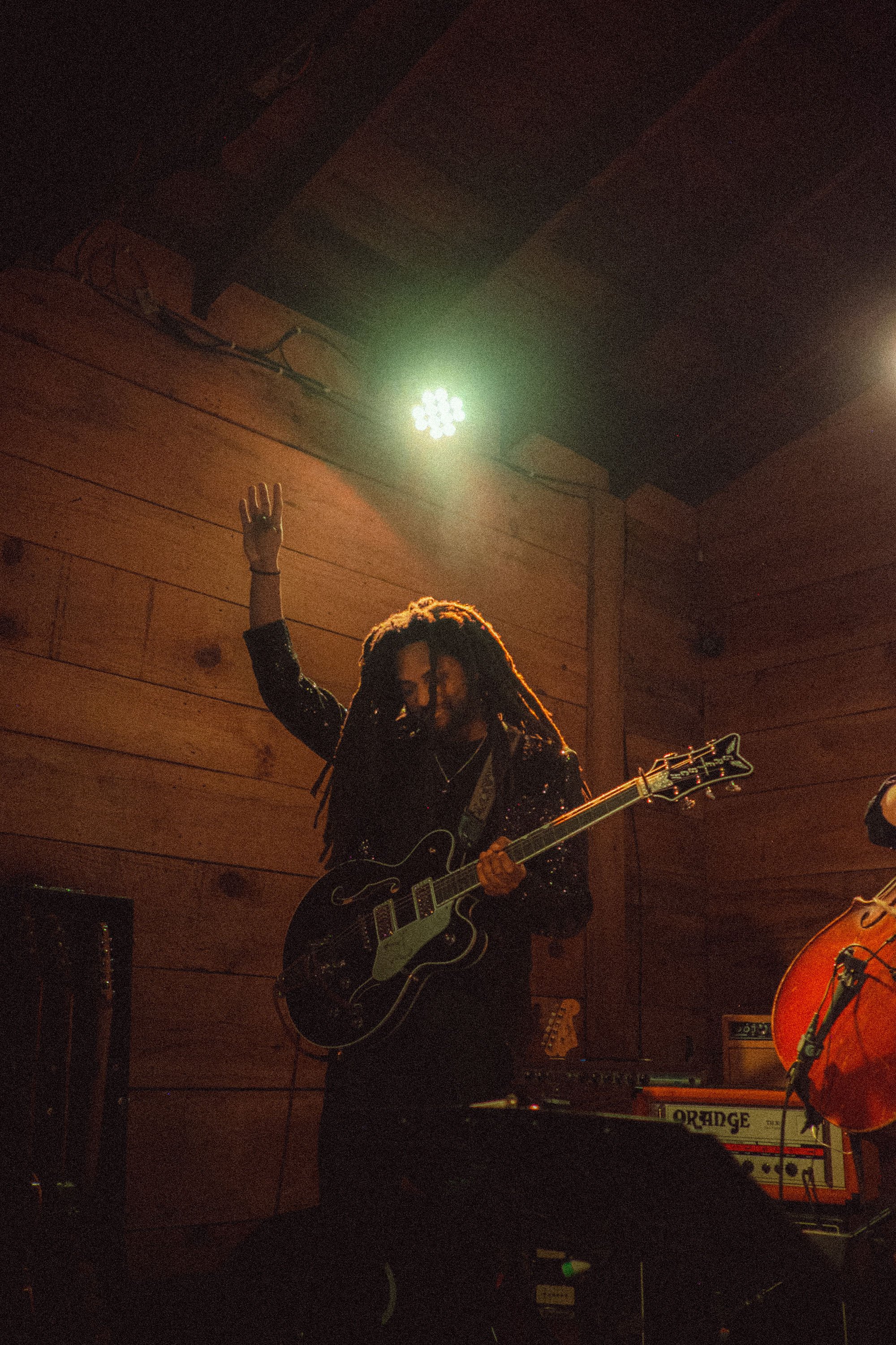 Q Clark live on stage under spotlights.