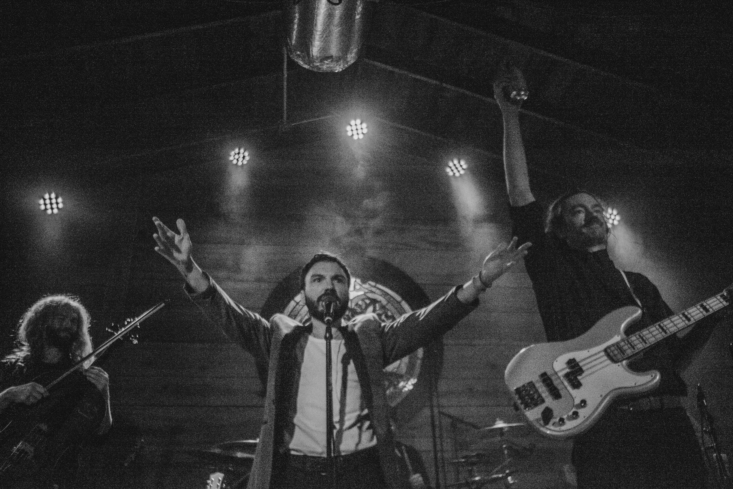 Cam Clark & His Orchestra commanding a crowd live, immersed in fog and stage lights.