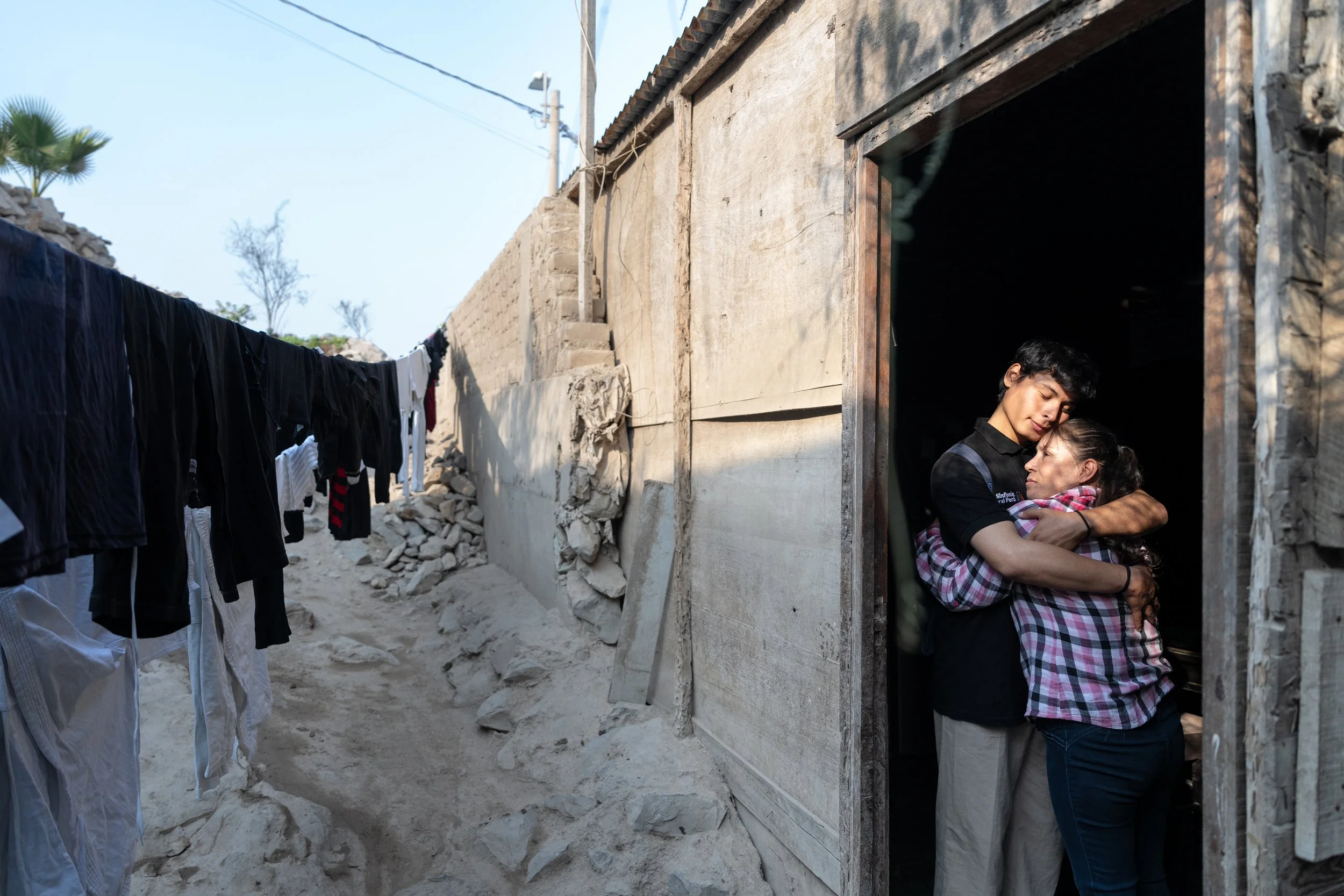 Carlos Vilca, member of the Sinfonía por el Perú Youth Choir at his home with his mother. In July 2024, he has won the Summa Cum Laude Youth Music Festival together with the Choir.