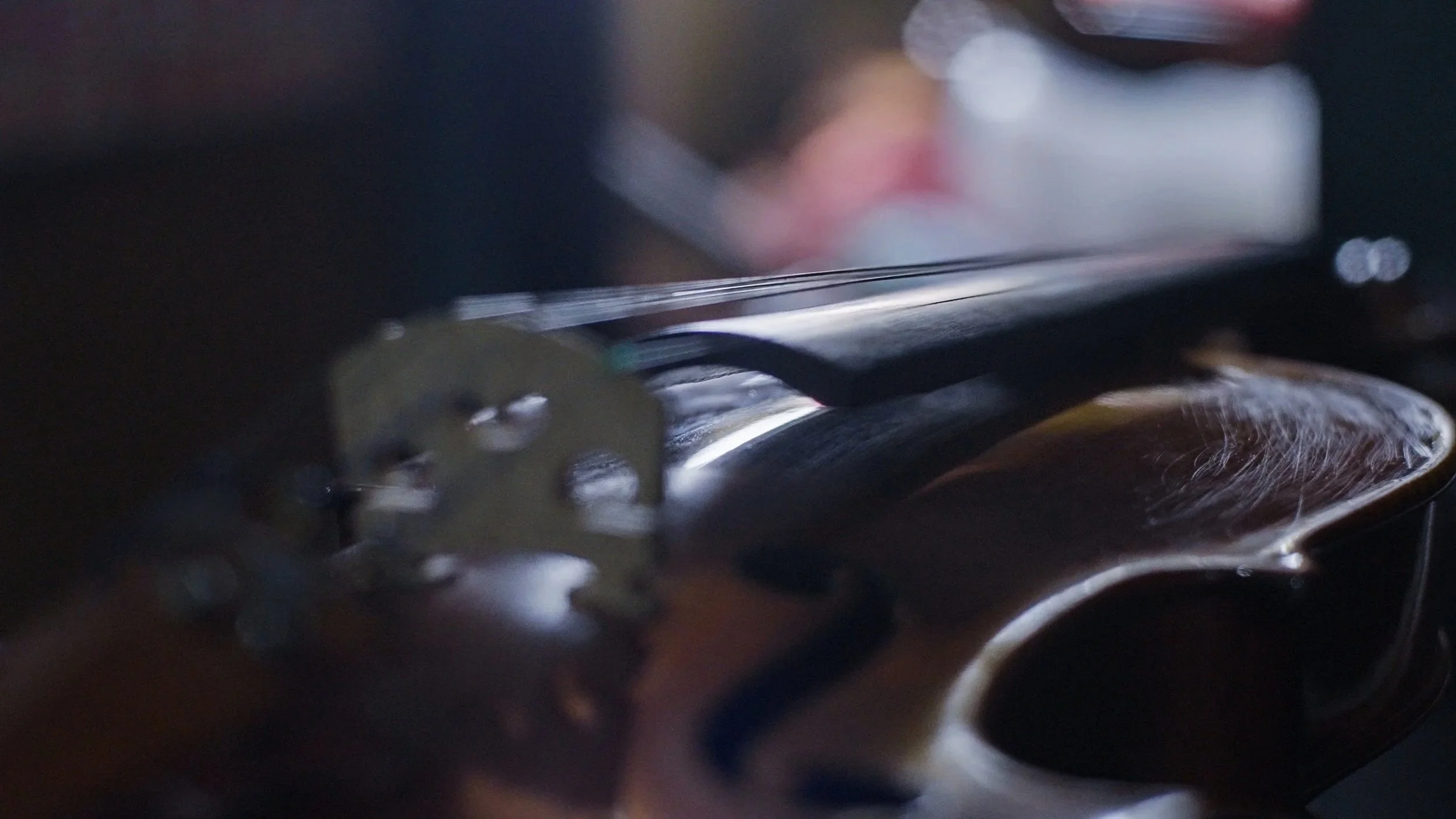 Close-up of a violin with visible scratches on the wood surface.