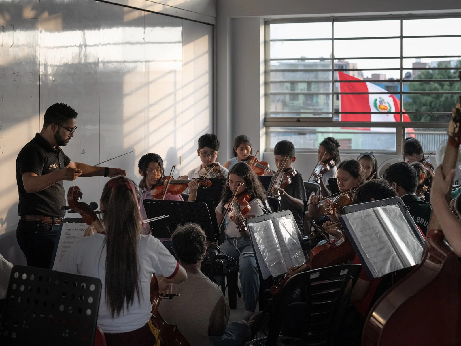 Music students from Sinfonia por el Peru rehearse in a classroom.