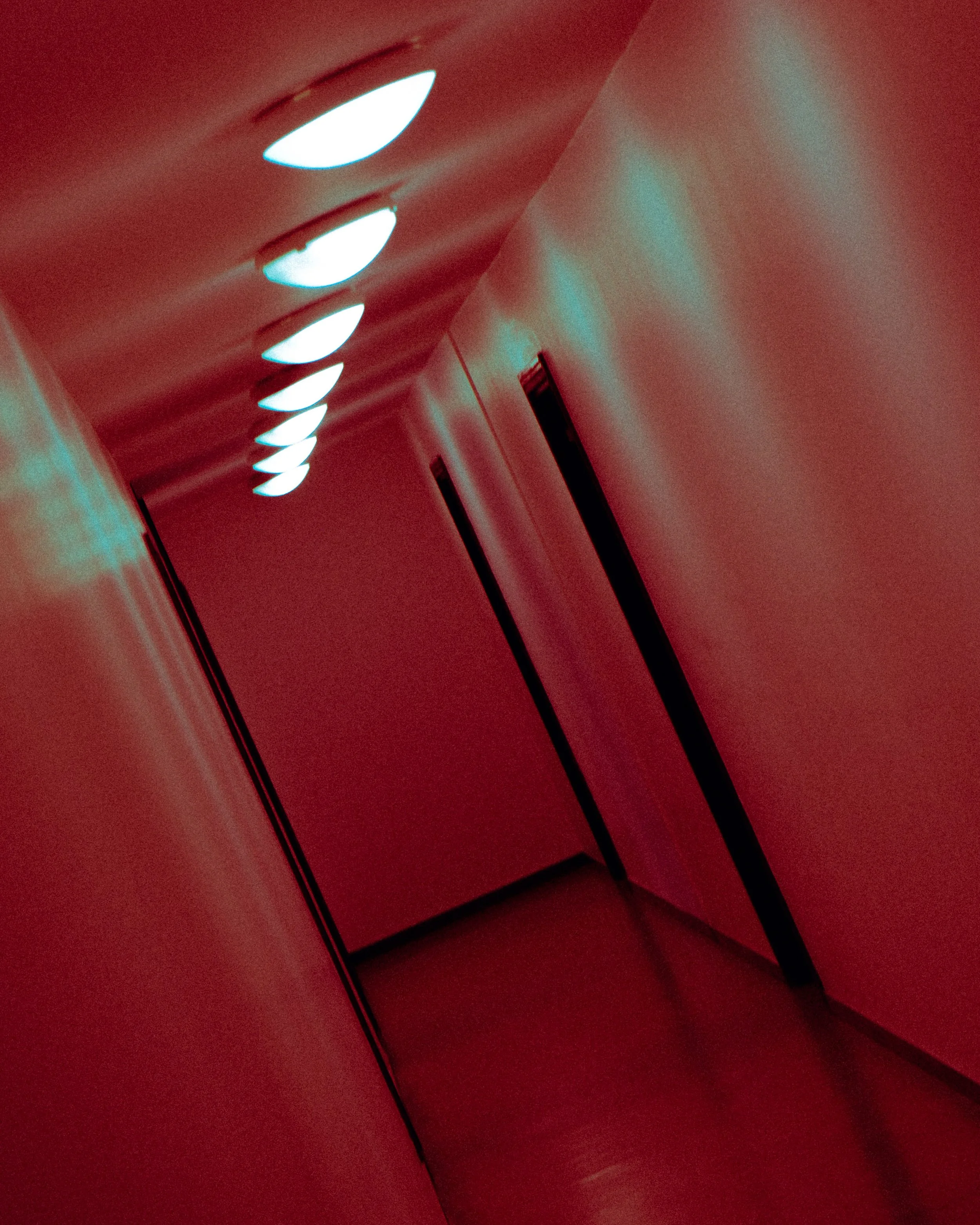 Couloir avec éclairage au plafond, ambiance rouge.