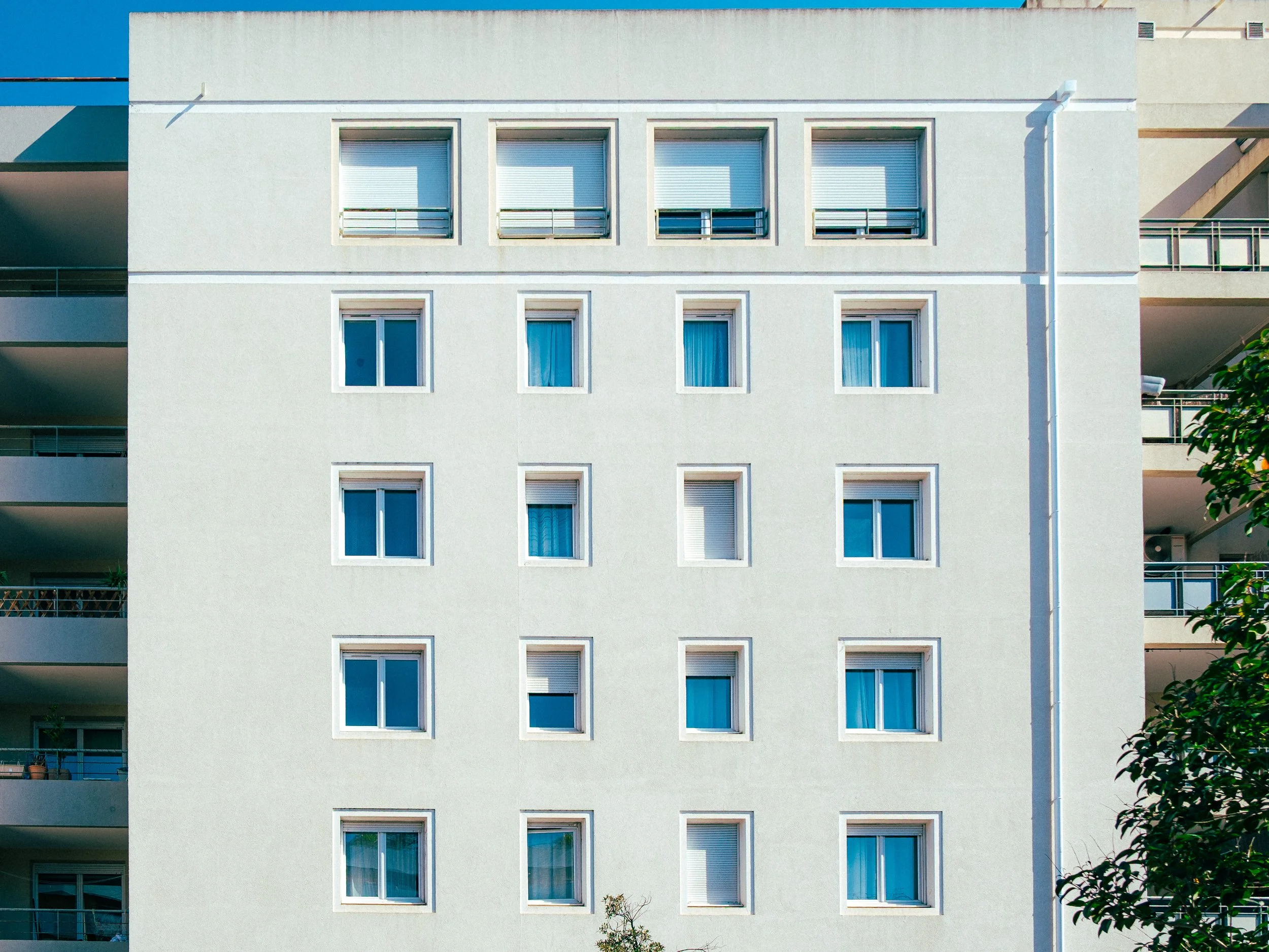 Façade d'un immeuble résidentiel avec plusieurs fenêtres.