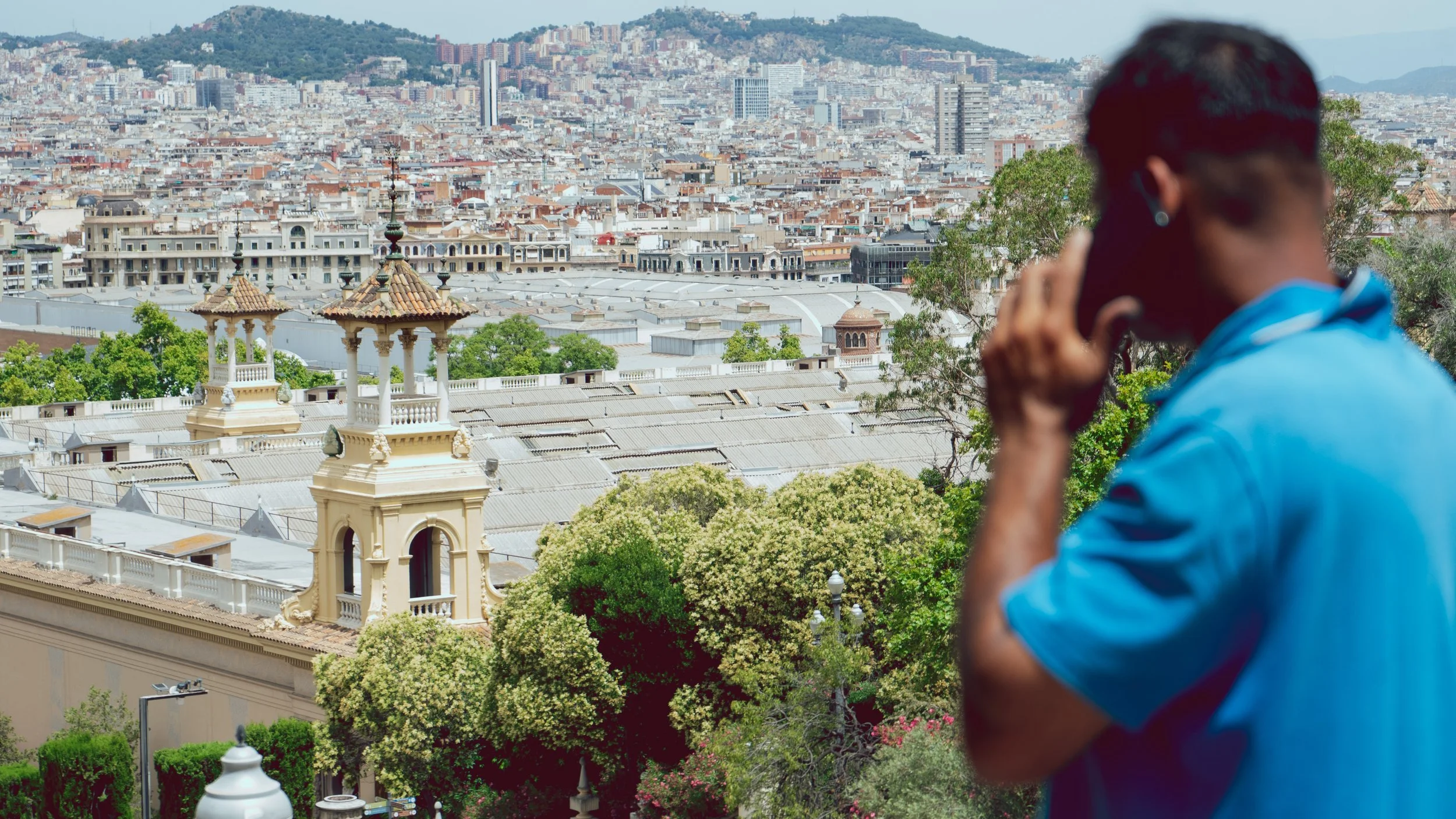 Vue de la ville avec des bâtiments historiques et un homme au téléphone au premier plan.