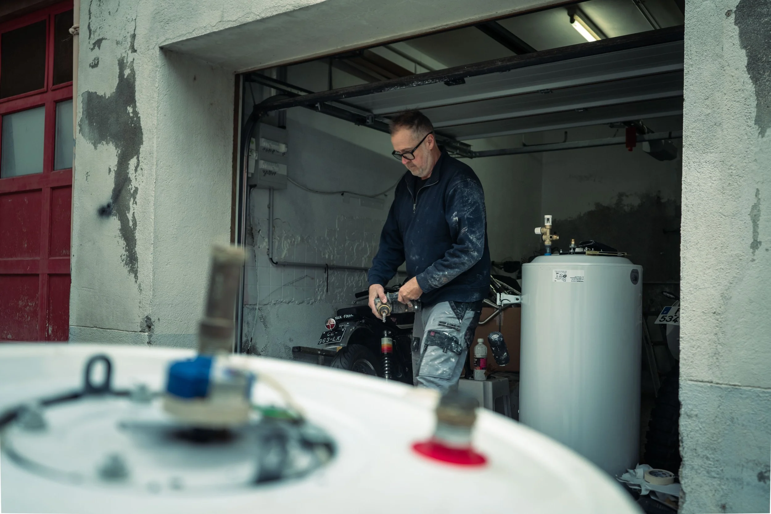 Homme travaillant dans un garage avec des appareils et une moto