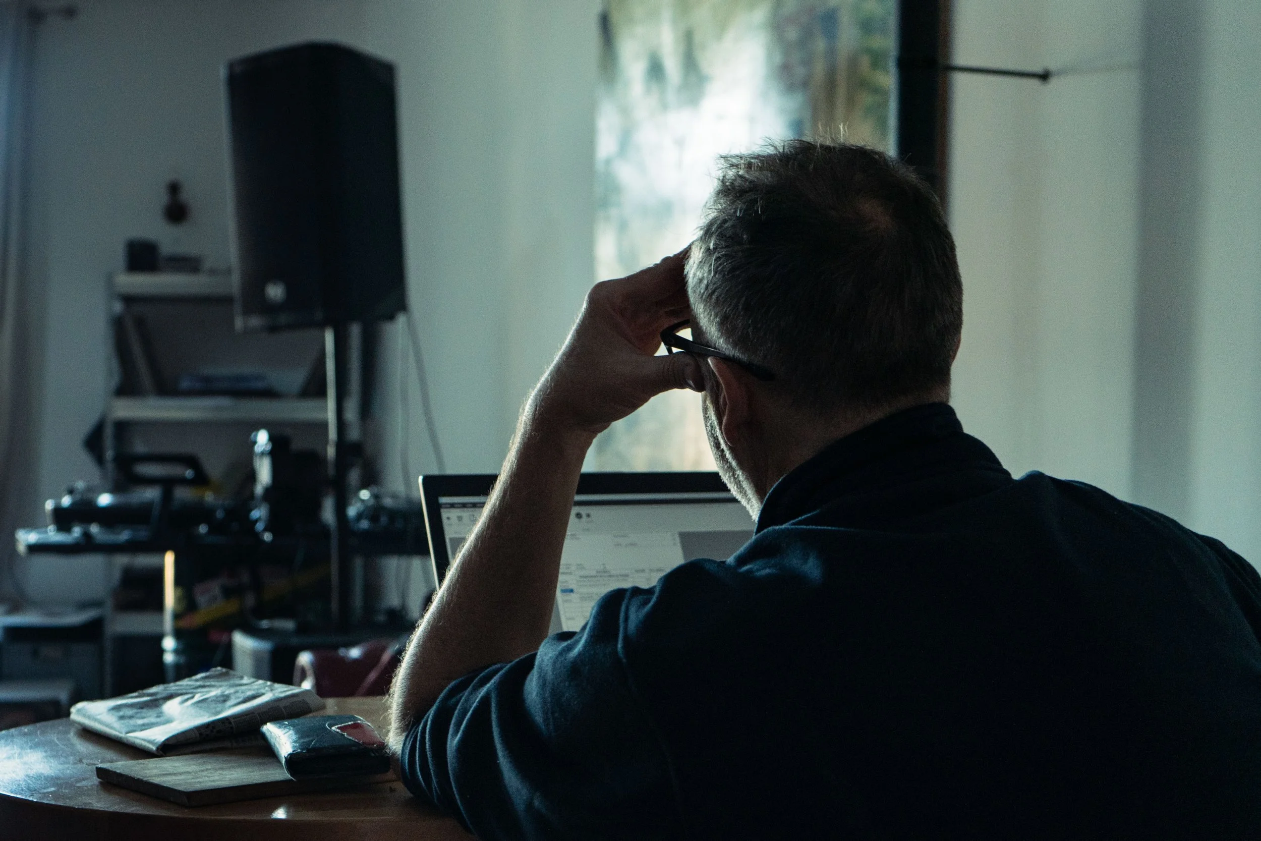 Homme travaillant sur un ordinateur portable dans une pièce sombre.