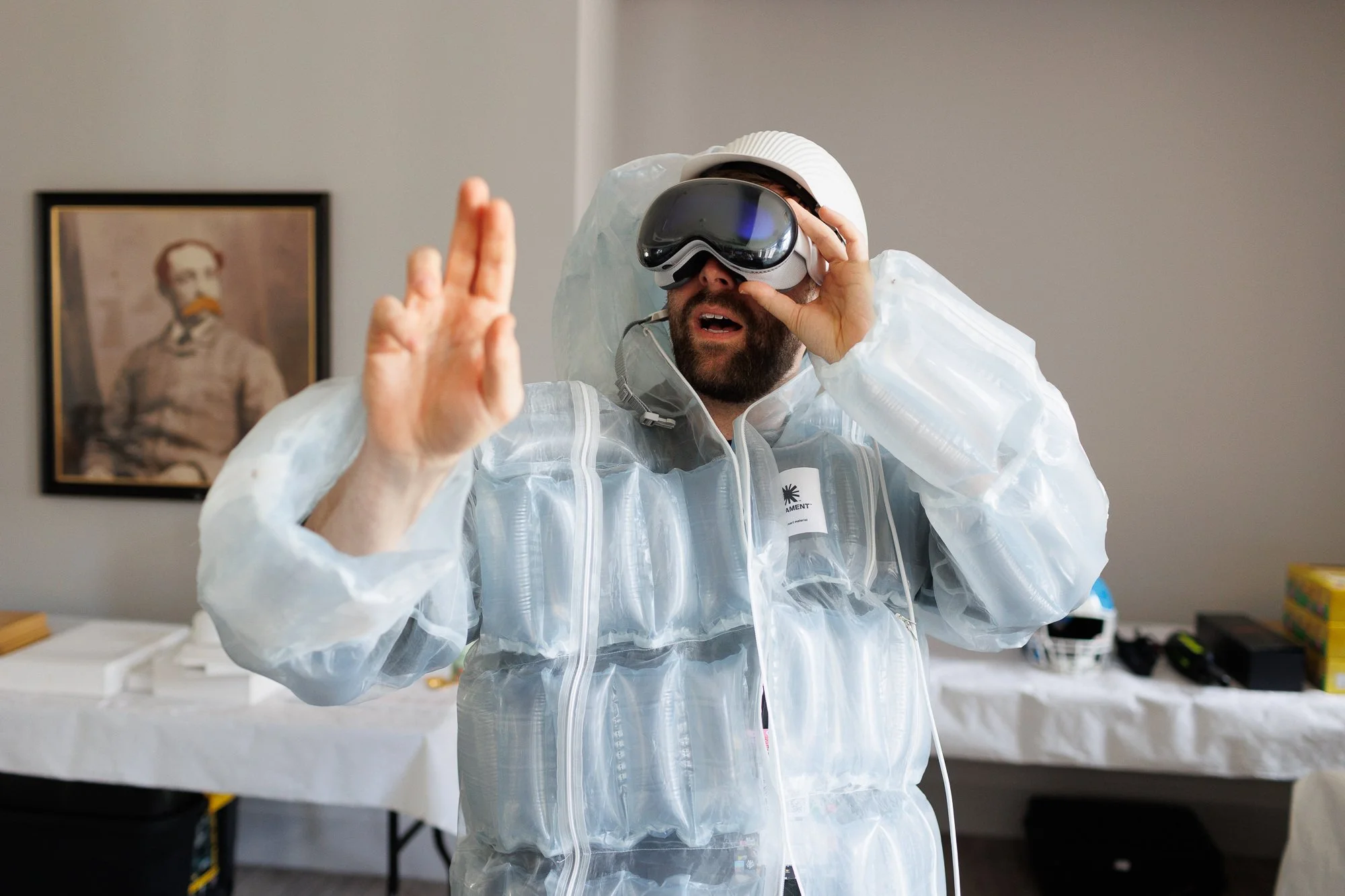 A man wearing a VR headset and white inflatable suit pointing upward during D&AD Pencil Awards judging.