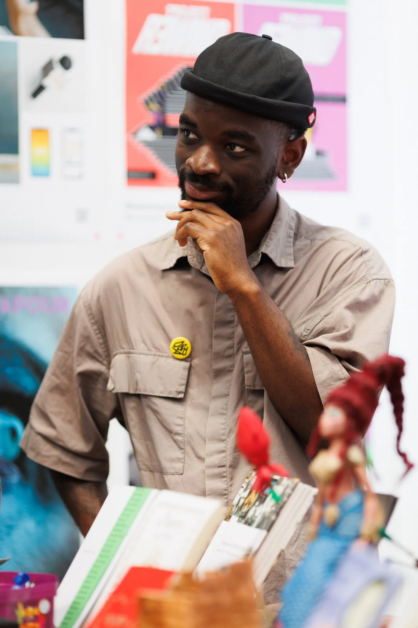 A man in a black beanie and tan shirt observing art displays at a creative festival in Protein Studios, Shoreditch.