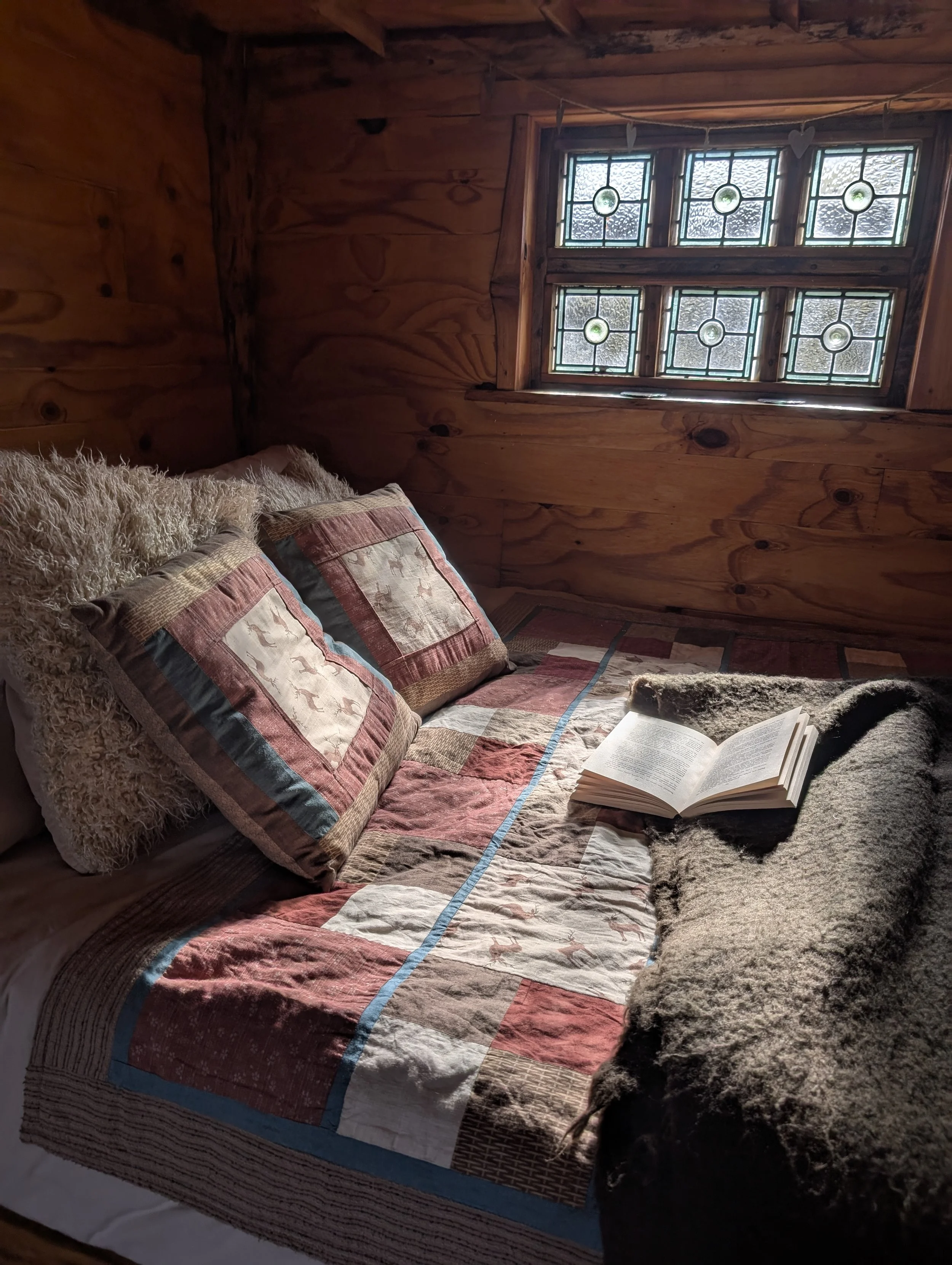 A book resting on the cosy bed at Coety Bach cabin in Mid Wales, perfect for a relaxing evening after visiting Hay Festival.