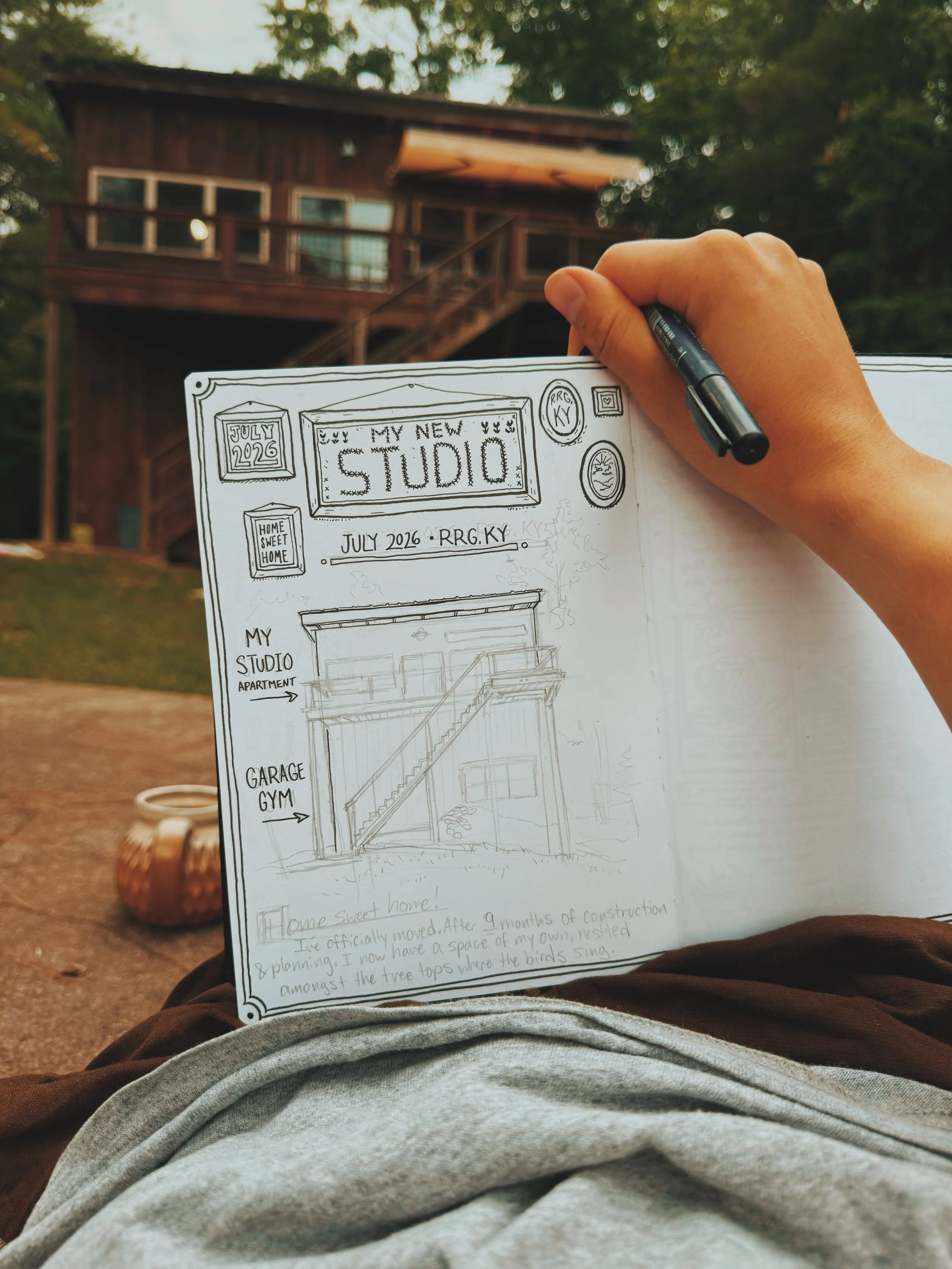 Sketchbook half filled with a drawing of a building labeled "my studio"