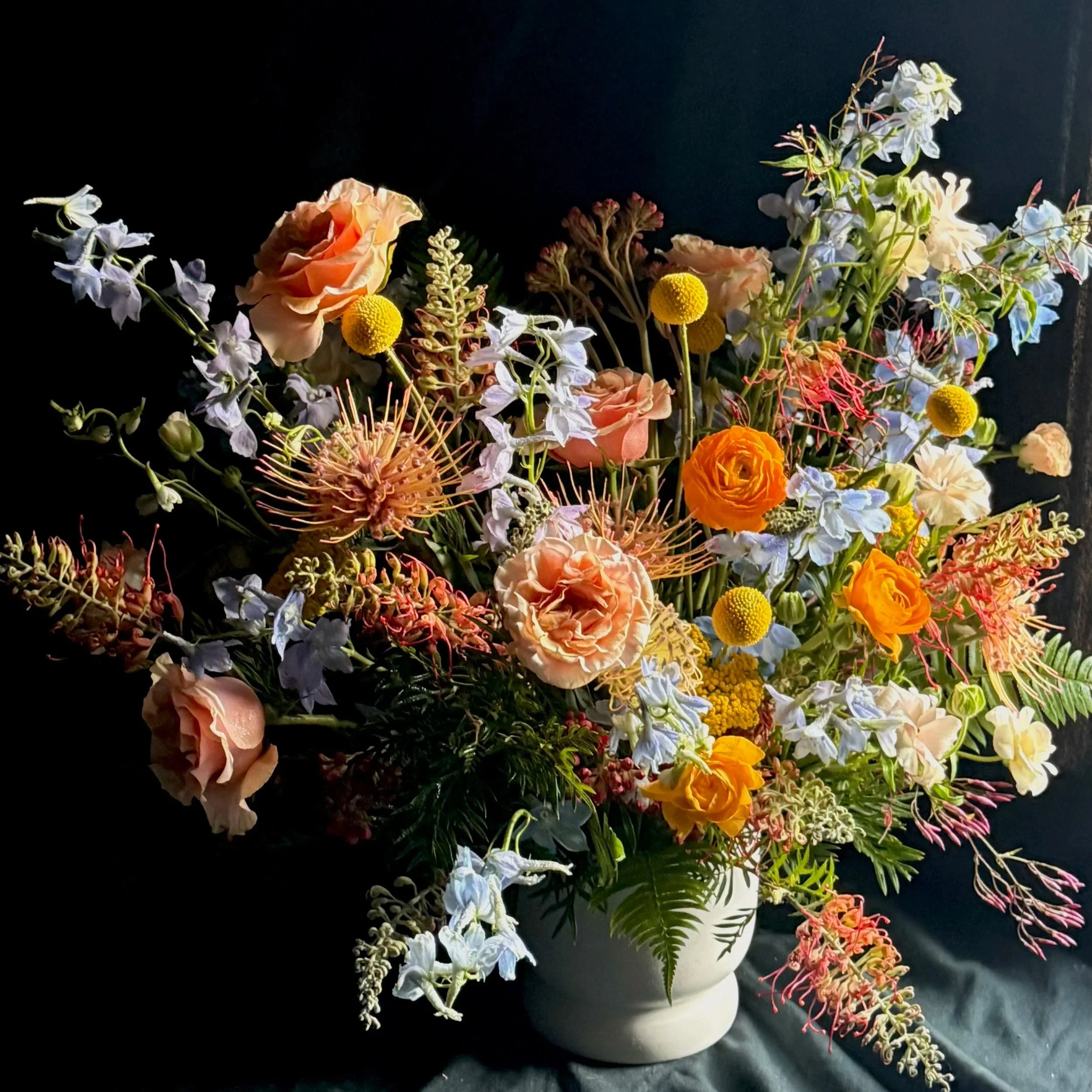 Luxury floral arrangement for birthday event groovy theme textured unique flowers in colorful color palette peach roses blues and yellows