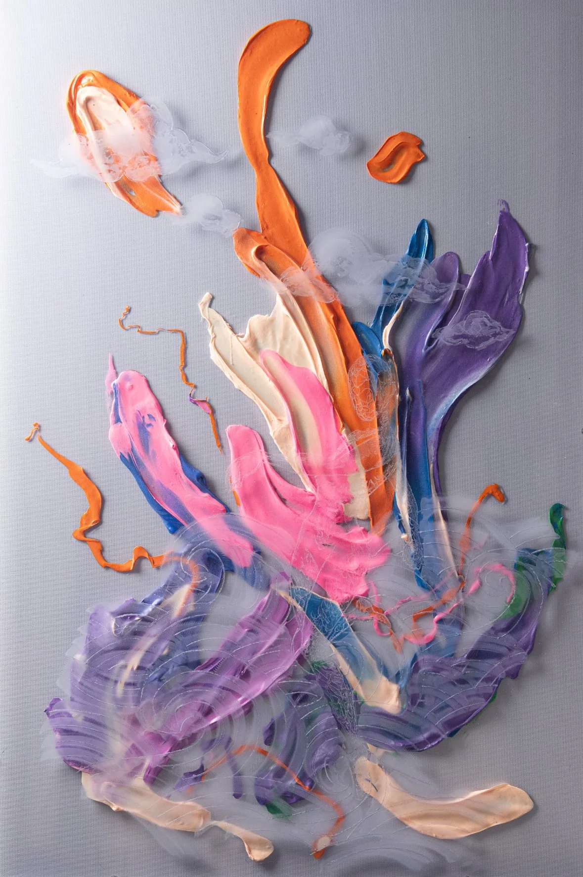 Abstract colorful paint splotches on a light gray background, resembling a floral or butterfly composition.