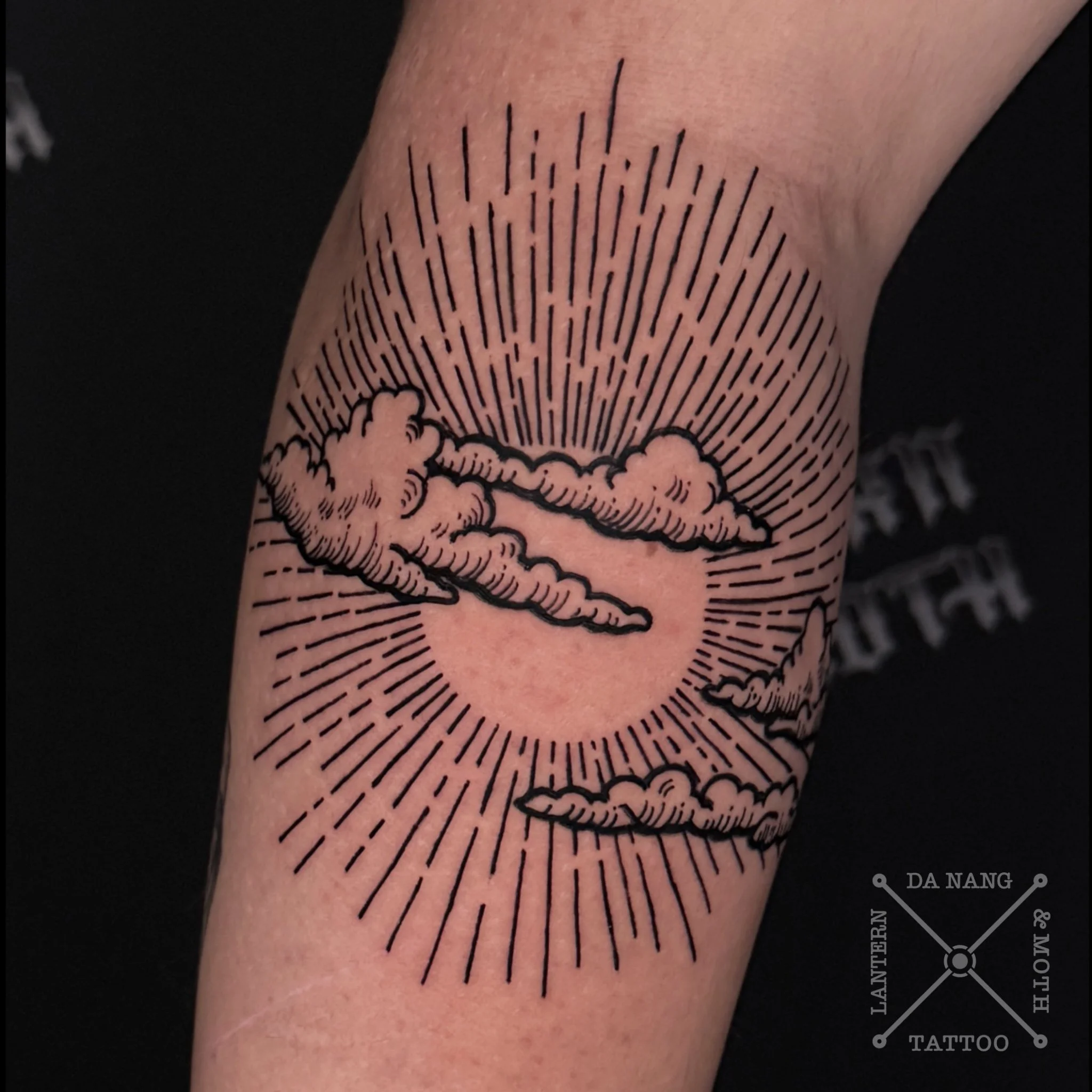 Illustrated style sun and clouds tattoo done at Lantern And Moth Tattoo Da Nang.