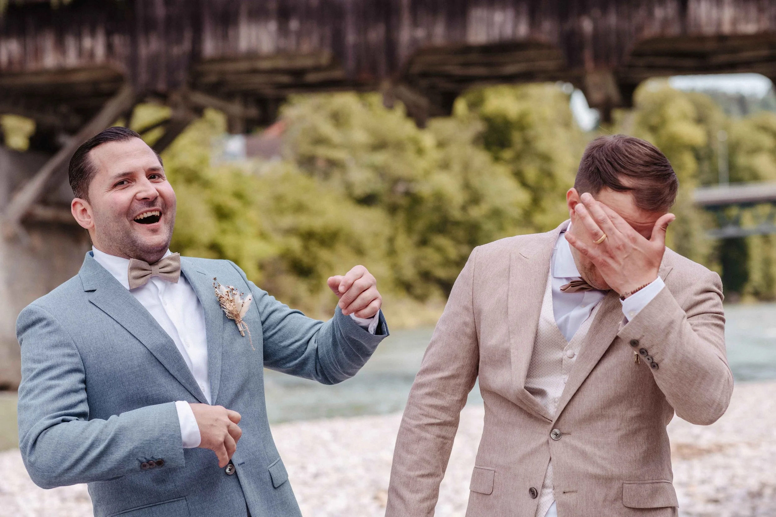 Bräutigam und Trauzeuge lachen und zeigt auf den anderen, der sein Gesicht mit der Hand bedeckt, .an der Thur.