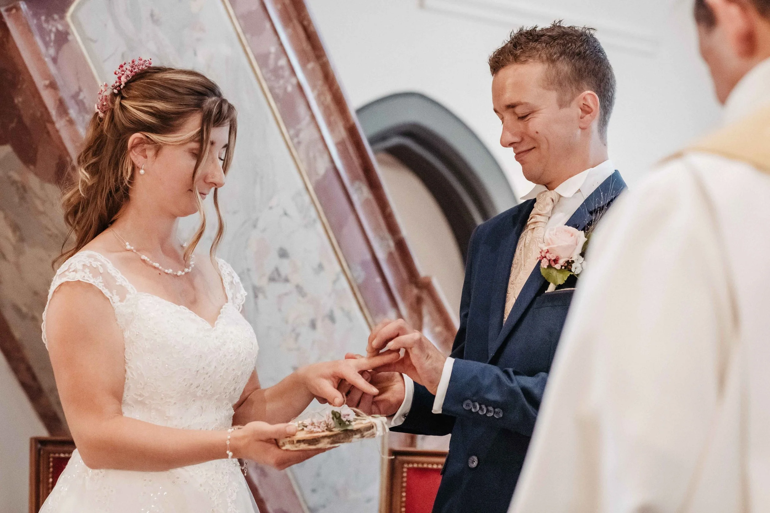 Brautpaar bei der Trauung, der Bräutigam legt einen Ring an die Braut.