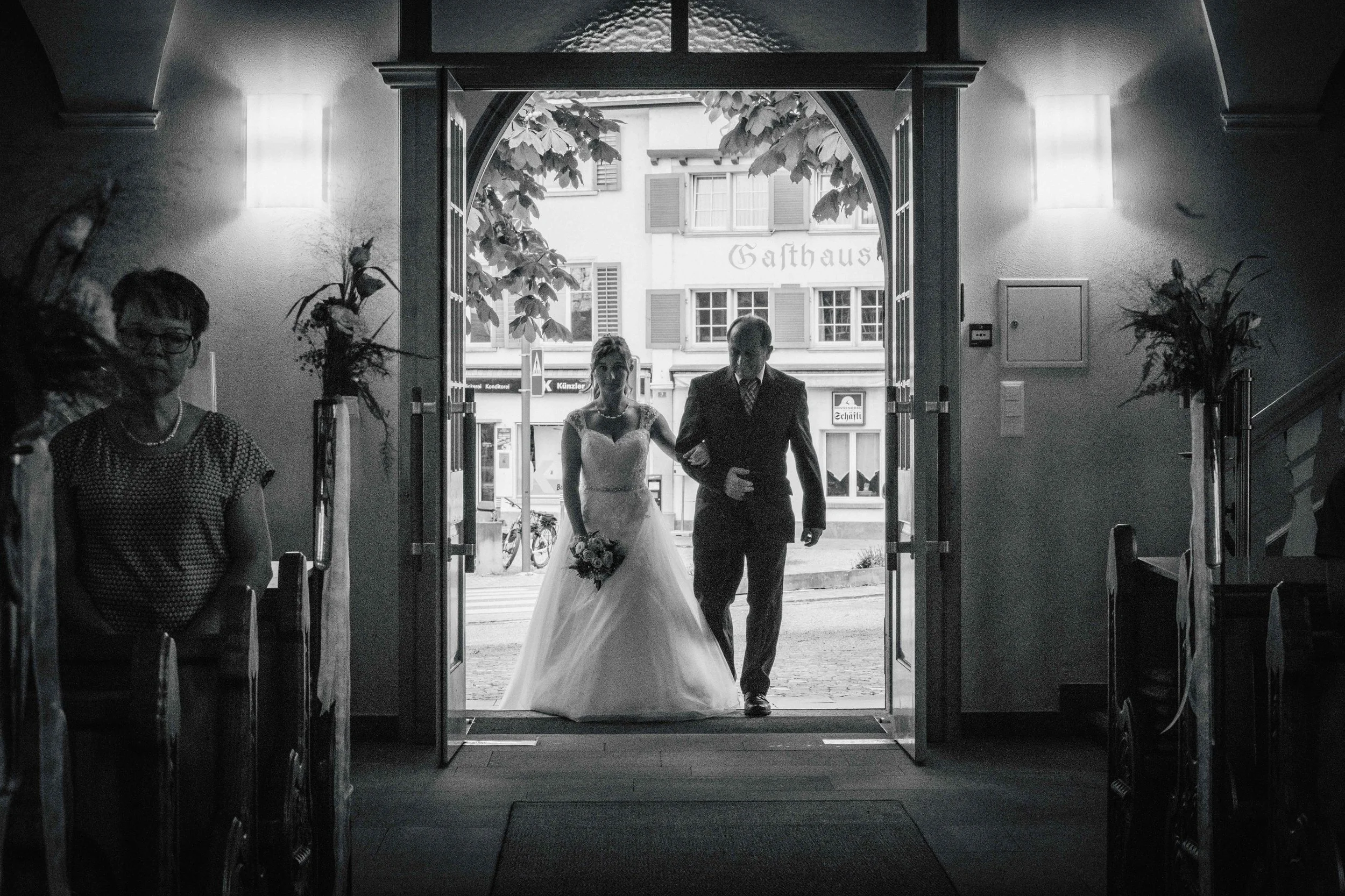 Braut und Bautvater kommen in die Kirche, schwarz-weiss.