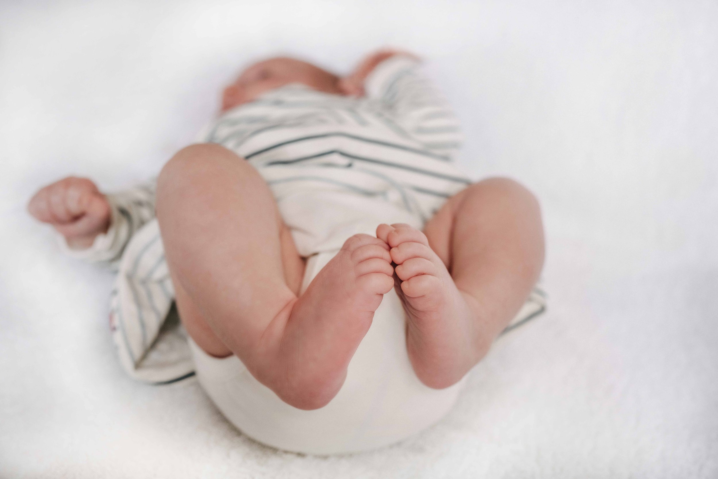 Nahaufnahme von Babyfüssen auf einem weissen Hintergrund.