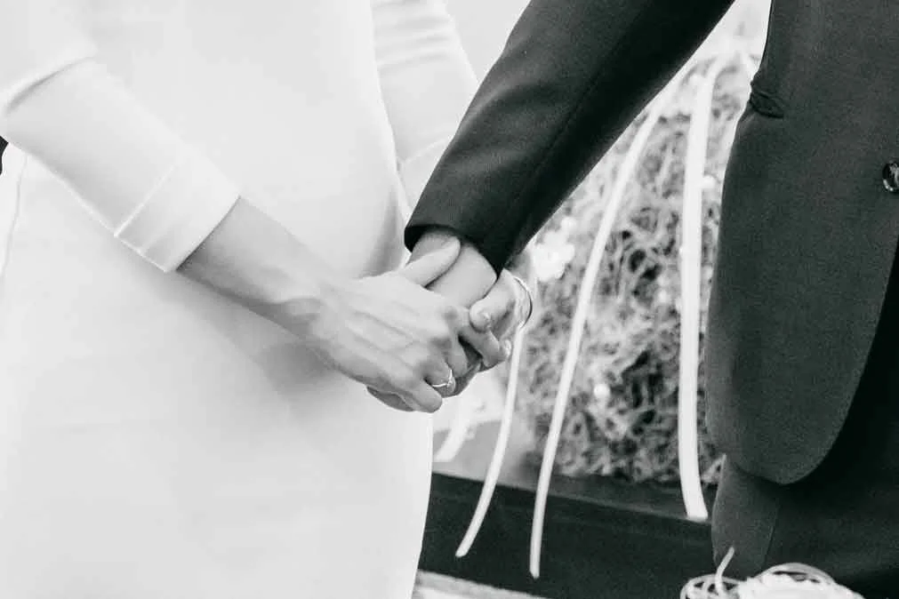 Brautpaar hält sich an den Händen. Nahaufnahmne.