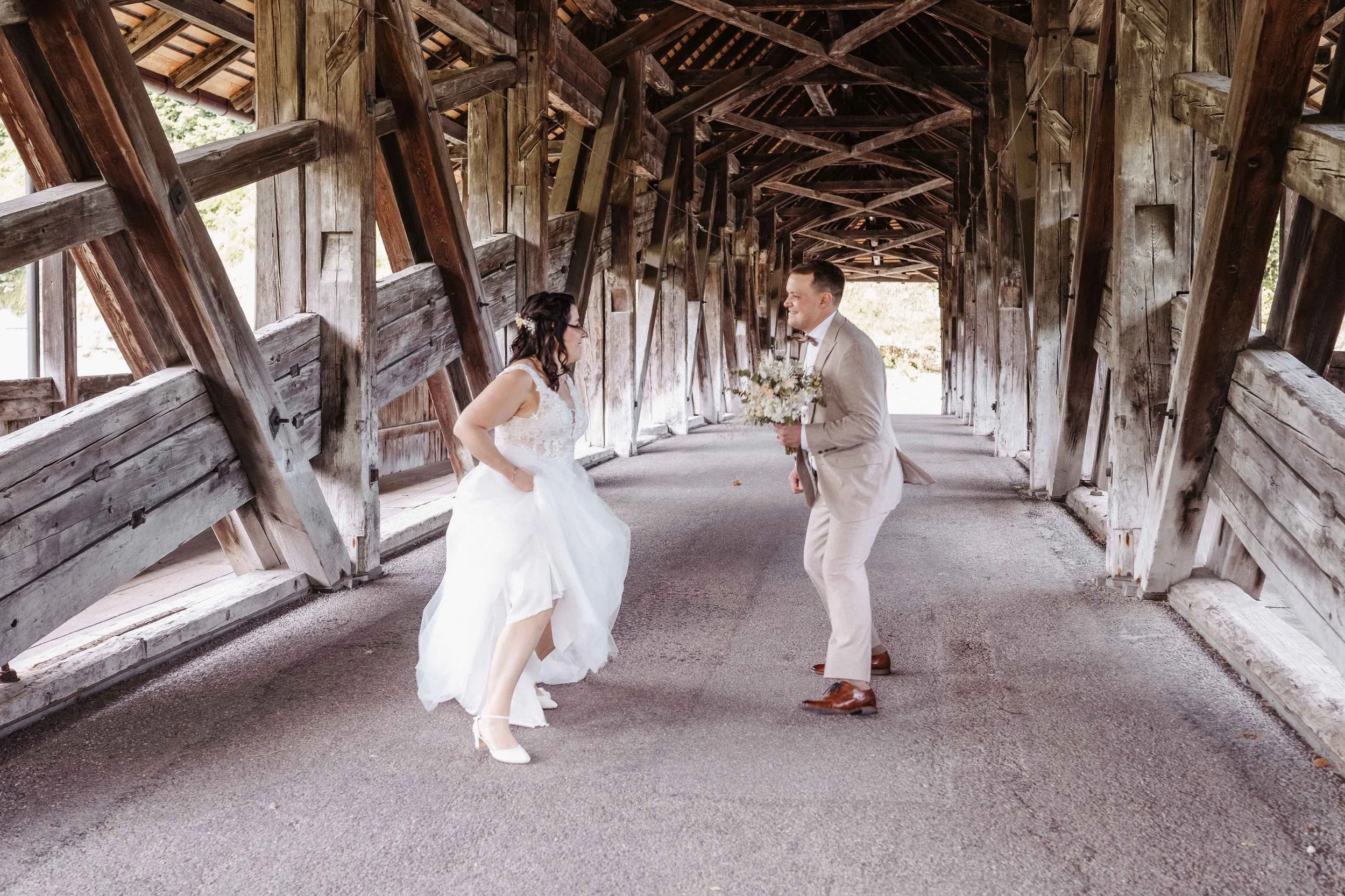 Brautpaar tanzt auf einer alten Holzbrücke.