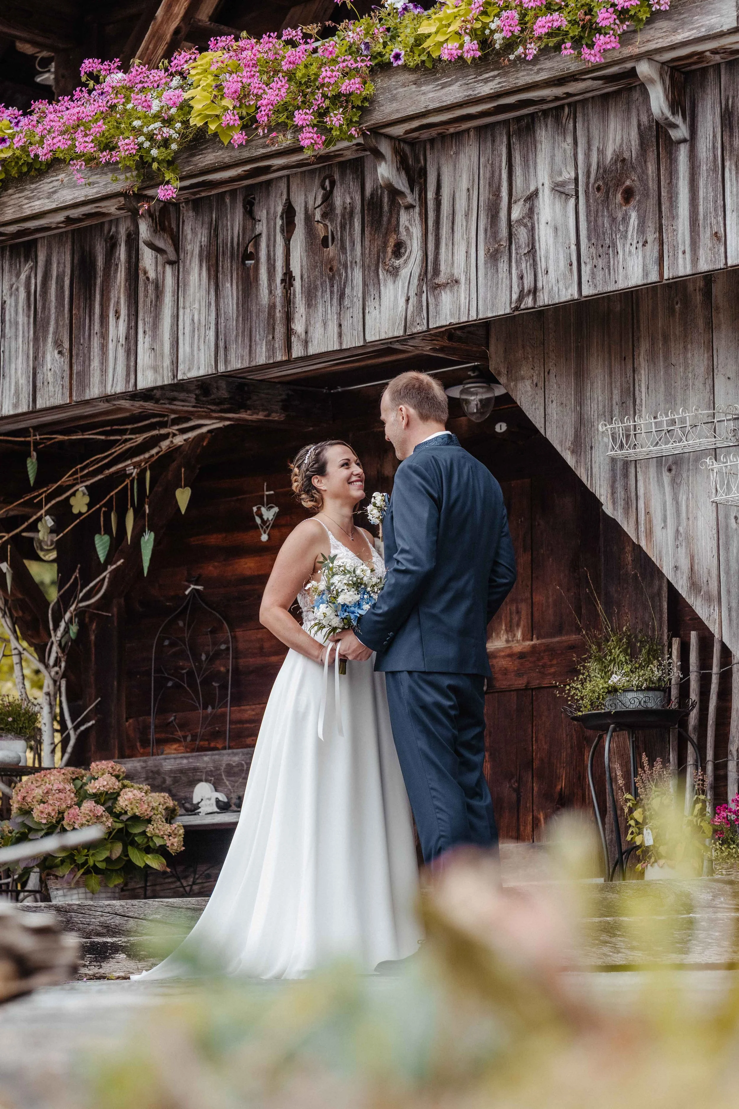 Brautpaar steht vor einem altem Schwatzspycher und schauen sich verliebt an.