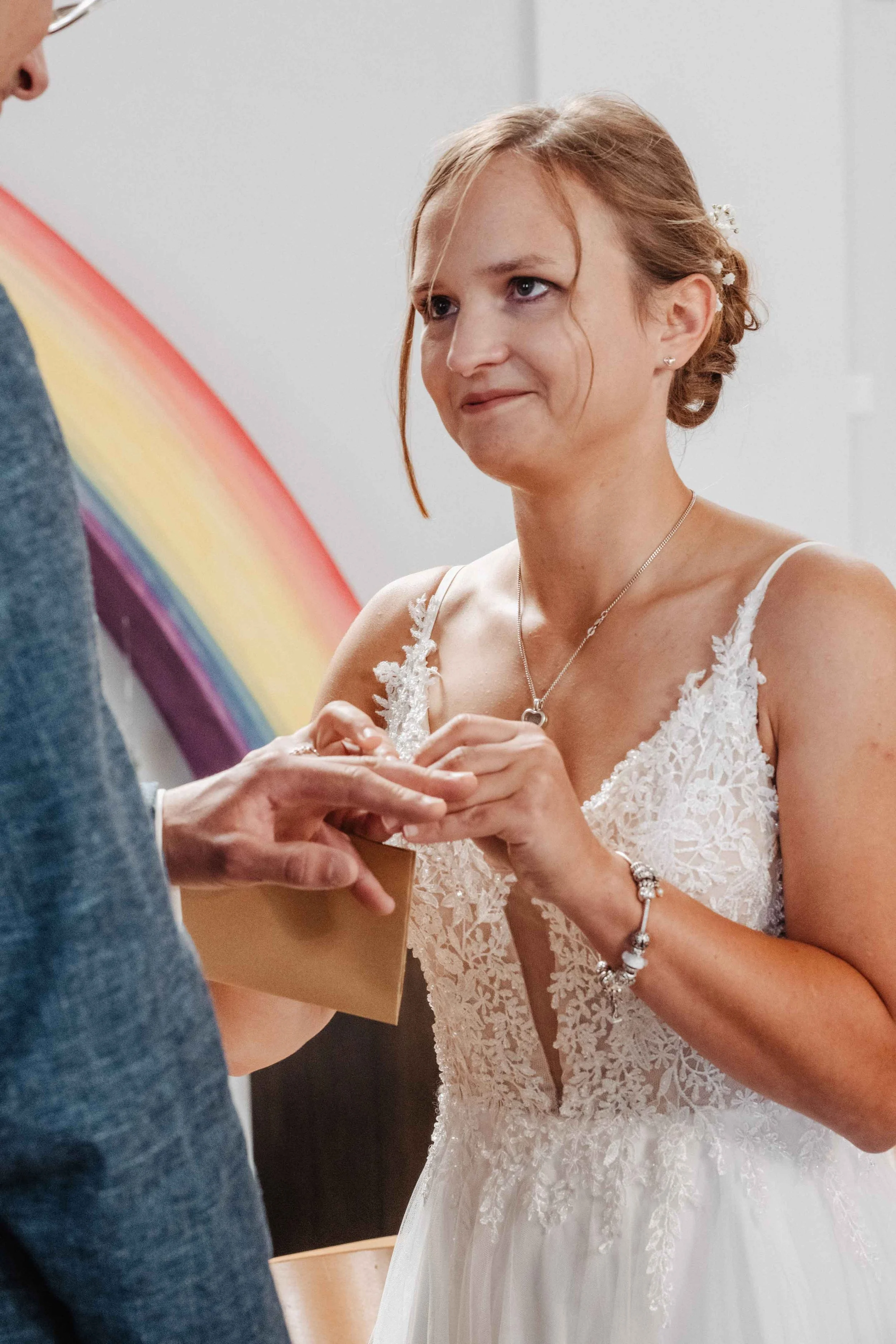 Braut in Brautkleid bei einer Trauungszeremonie, die einen Ring erhält.