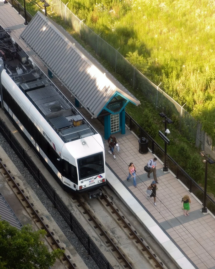 People walking away from a NJ Transit light rail car