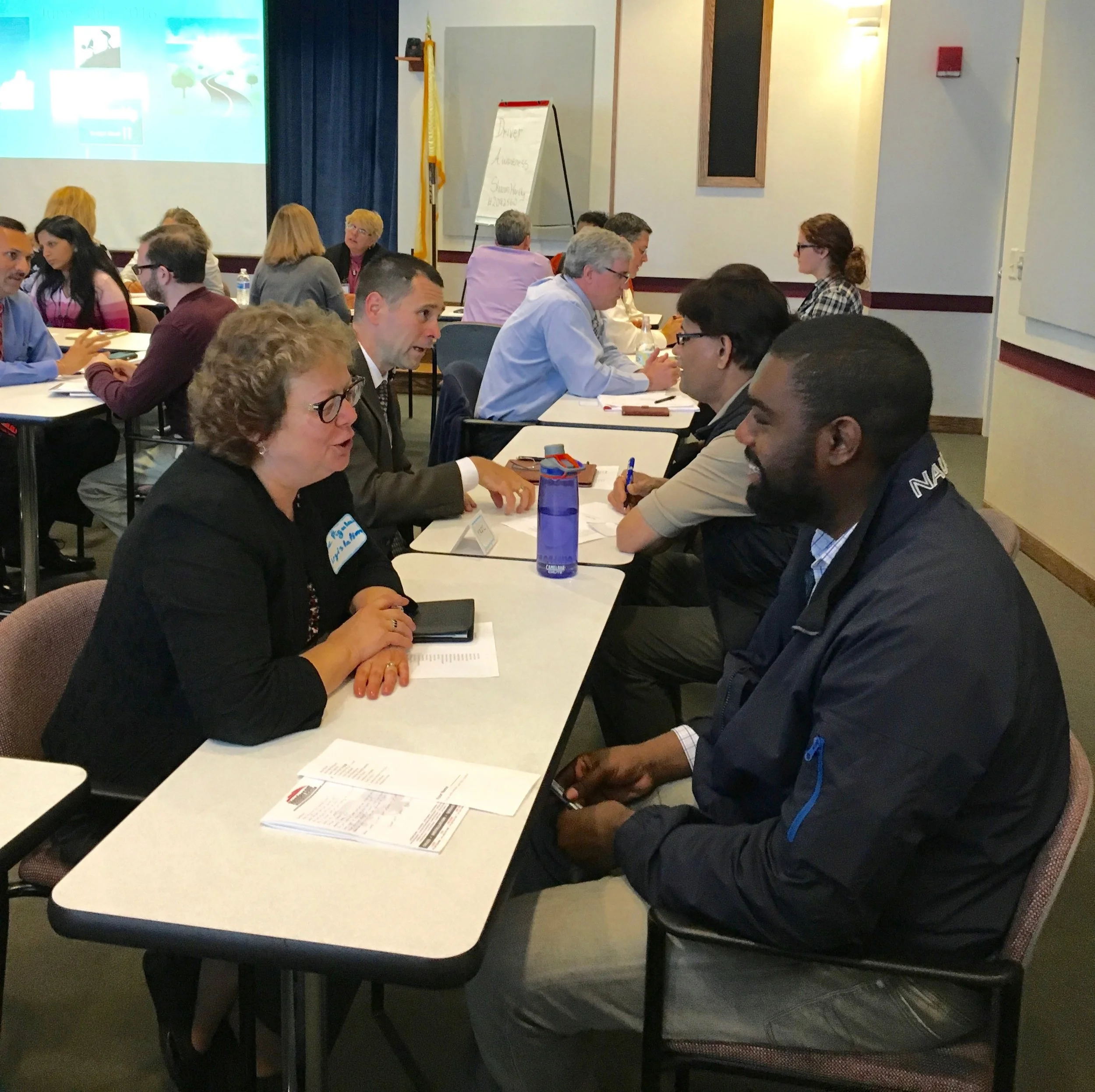 A room of people speaking to each other one on one