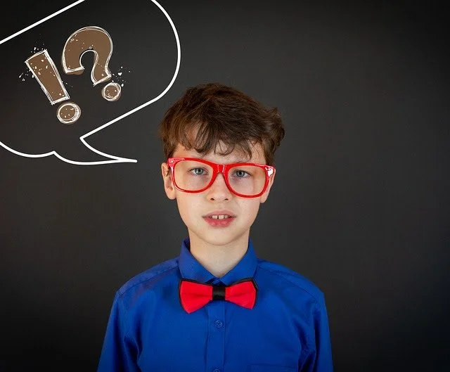 boy in front of a chalkboard with a question mark