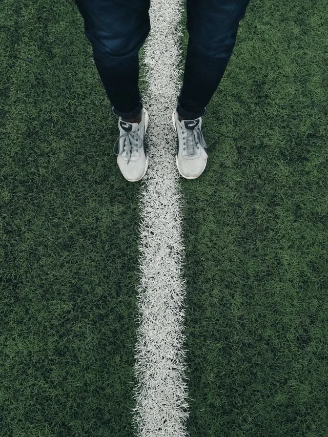 Person standing with one foot on either side of a line