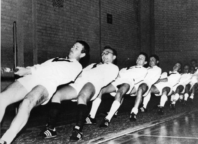 Men struggling to pull a rope