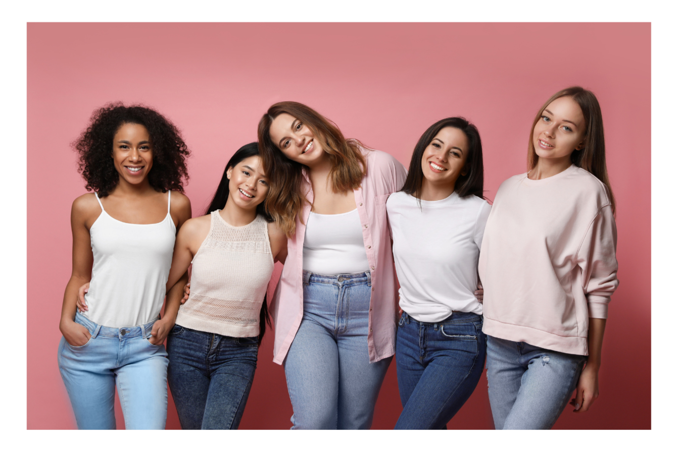 Group of five diverse women smiling and posing together against a pink background.