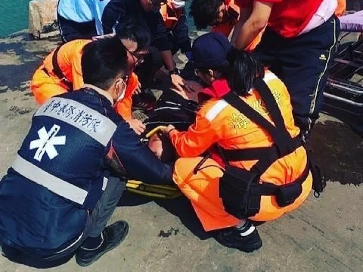 Emergency responders and paramedics attending to a person on the ground and providing medical assistance.