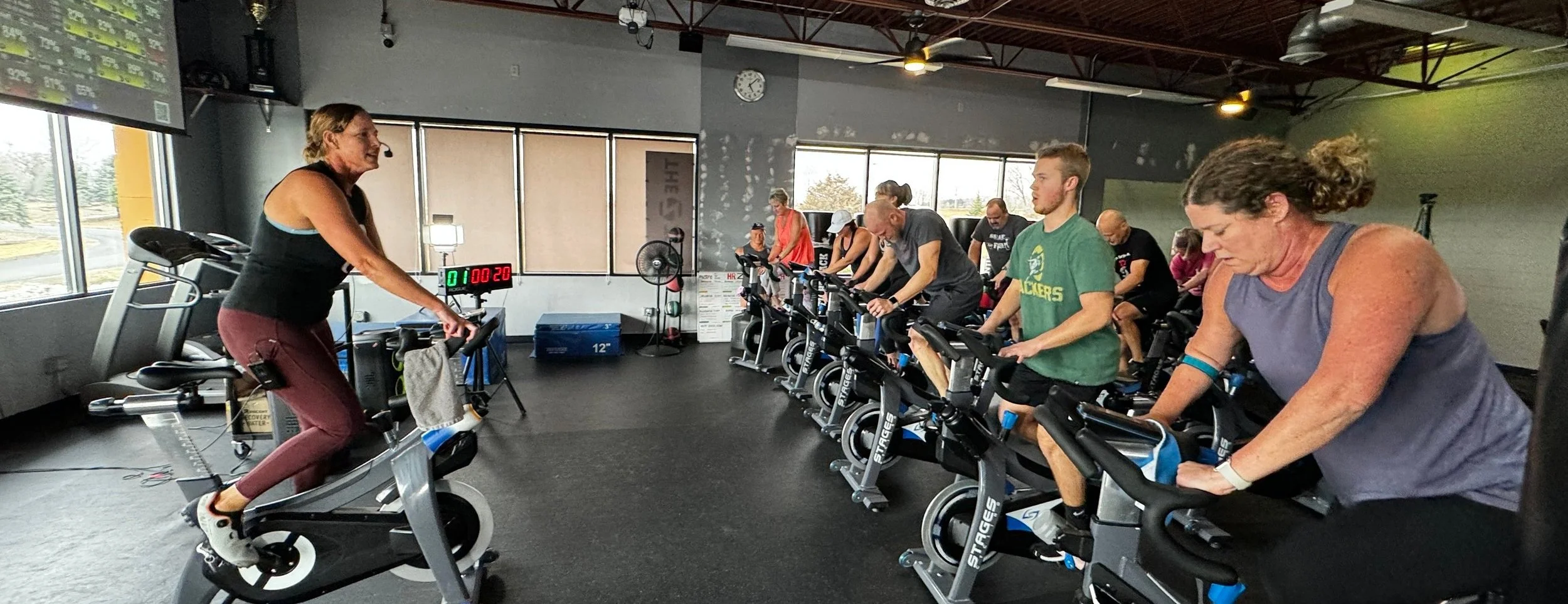 Instructor motivating riders during an energetic spin class at The Zone Fitness.
