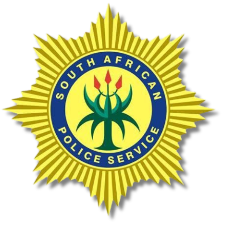 The emblem of the South African Police Service featuring a yellow shield with a blue circle containing a green protea flower and red flames, surrounded by a yellow sunburst pattern.