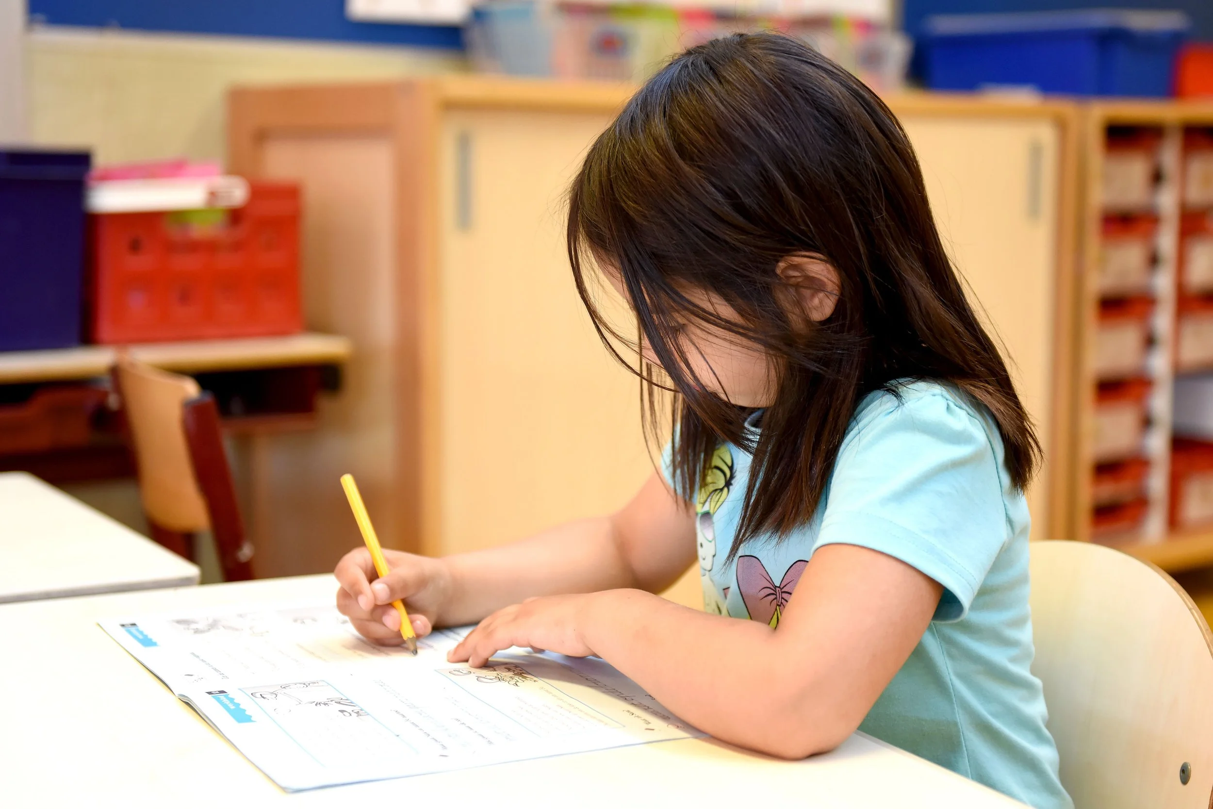 a child doing school work on a desk