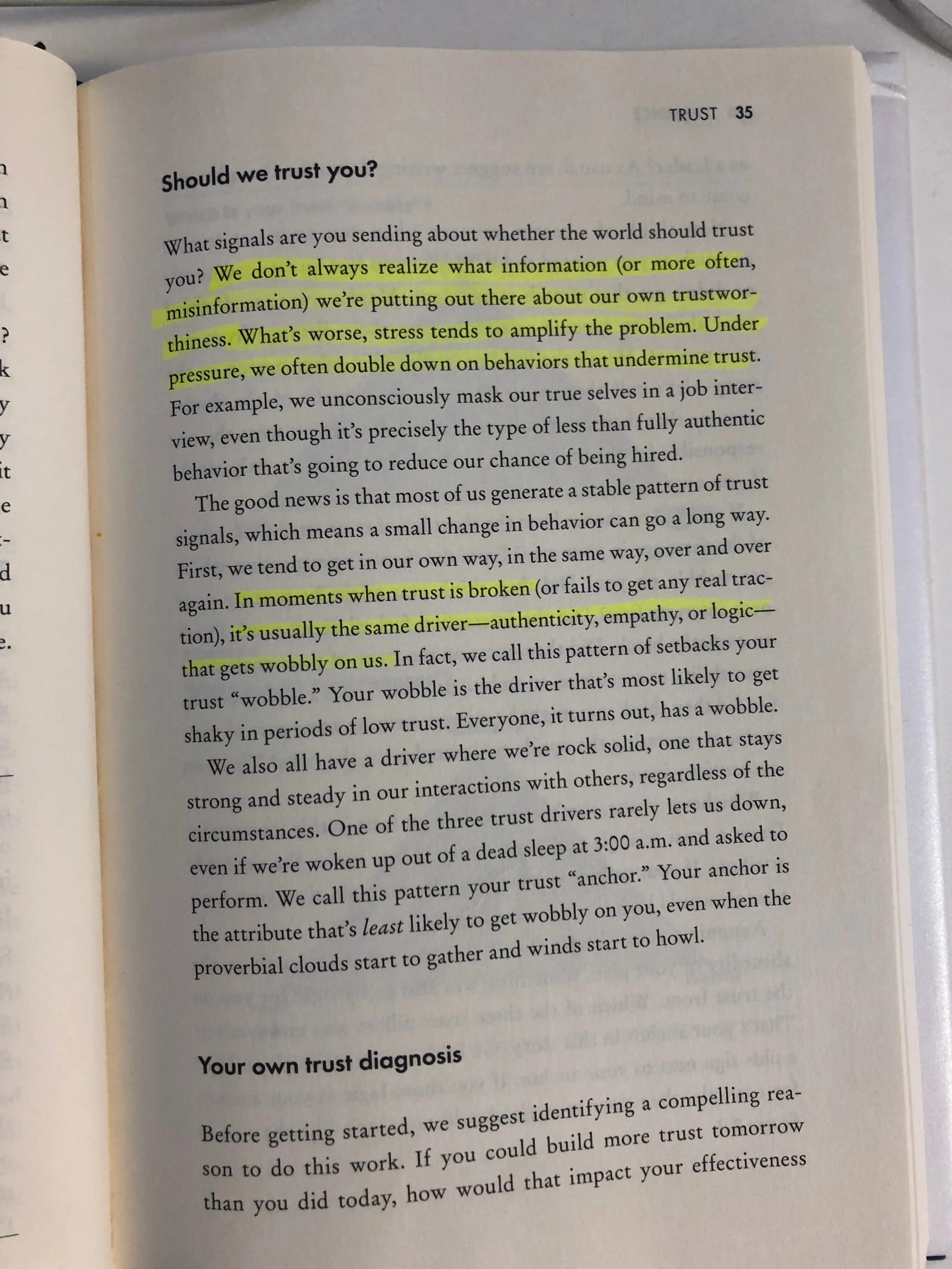 Open book page with highlighted text discussing trust, stress, authenticity, and behaviors, under the titles "Should we trust you?" and "Your own trust diagnosis".