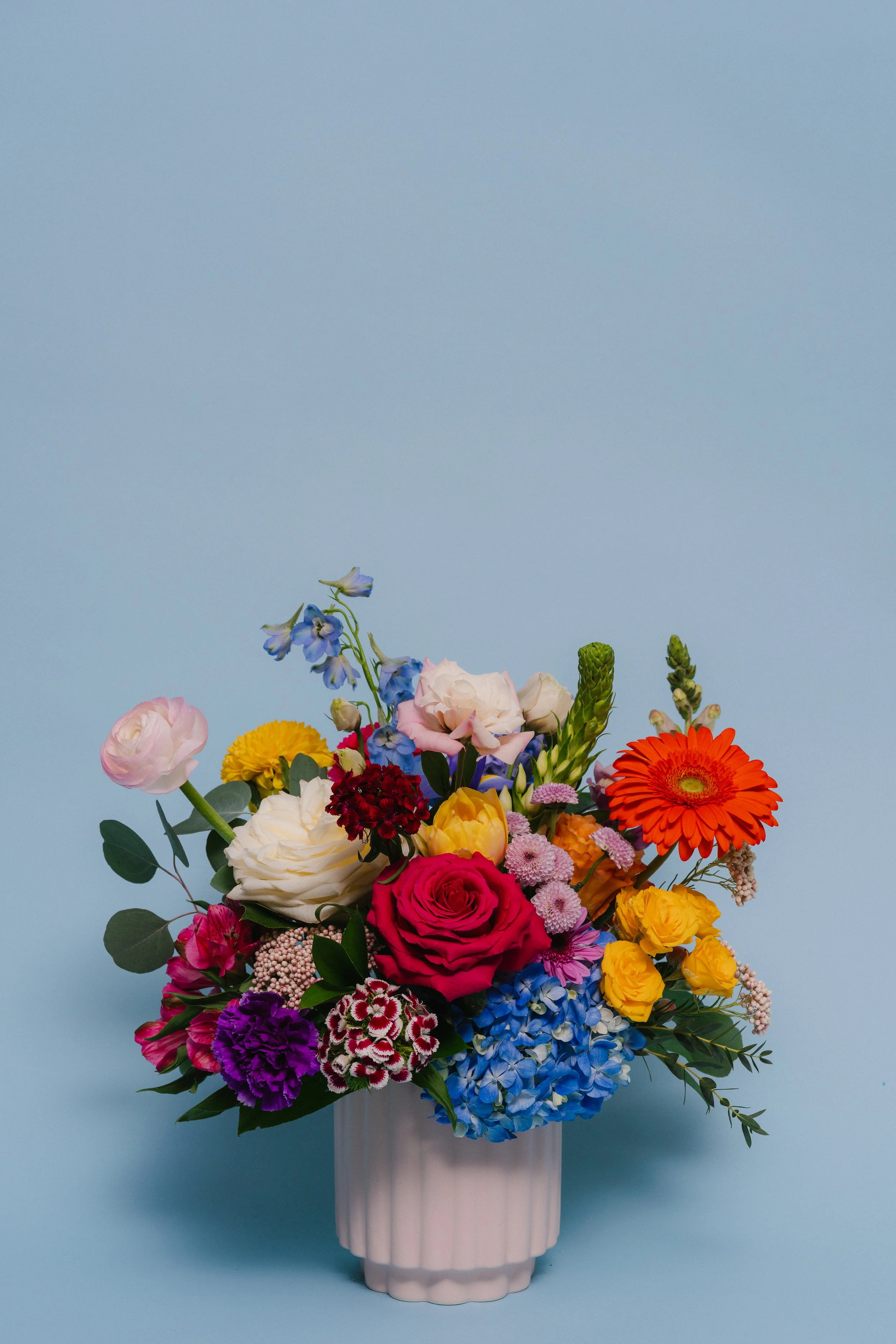 Pretty Momma - a medium size low & lush bouquet in a contemporary ceramic pot filled with vibrant flowers. Varieties will vary depending on availability - $129.95