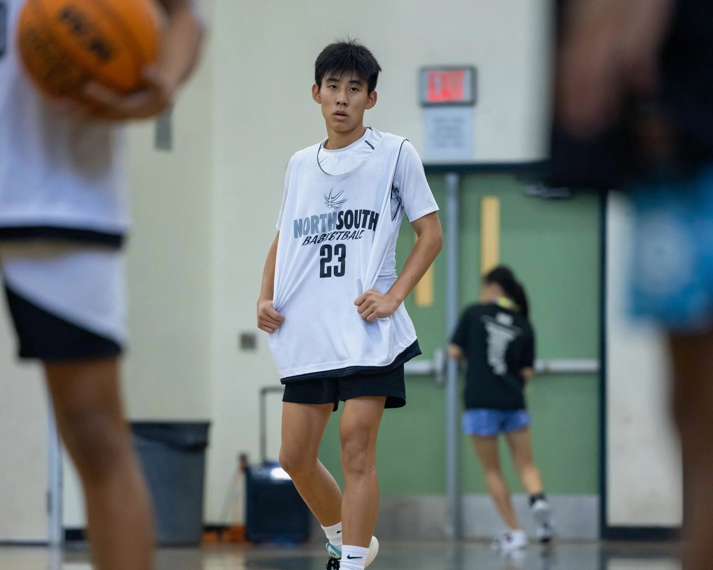 Basketball player wearing a "North South Basketball" jersey with the number 23 indoors during practice.