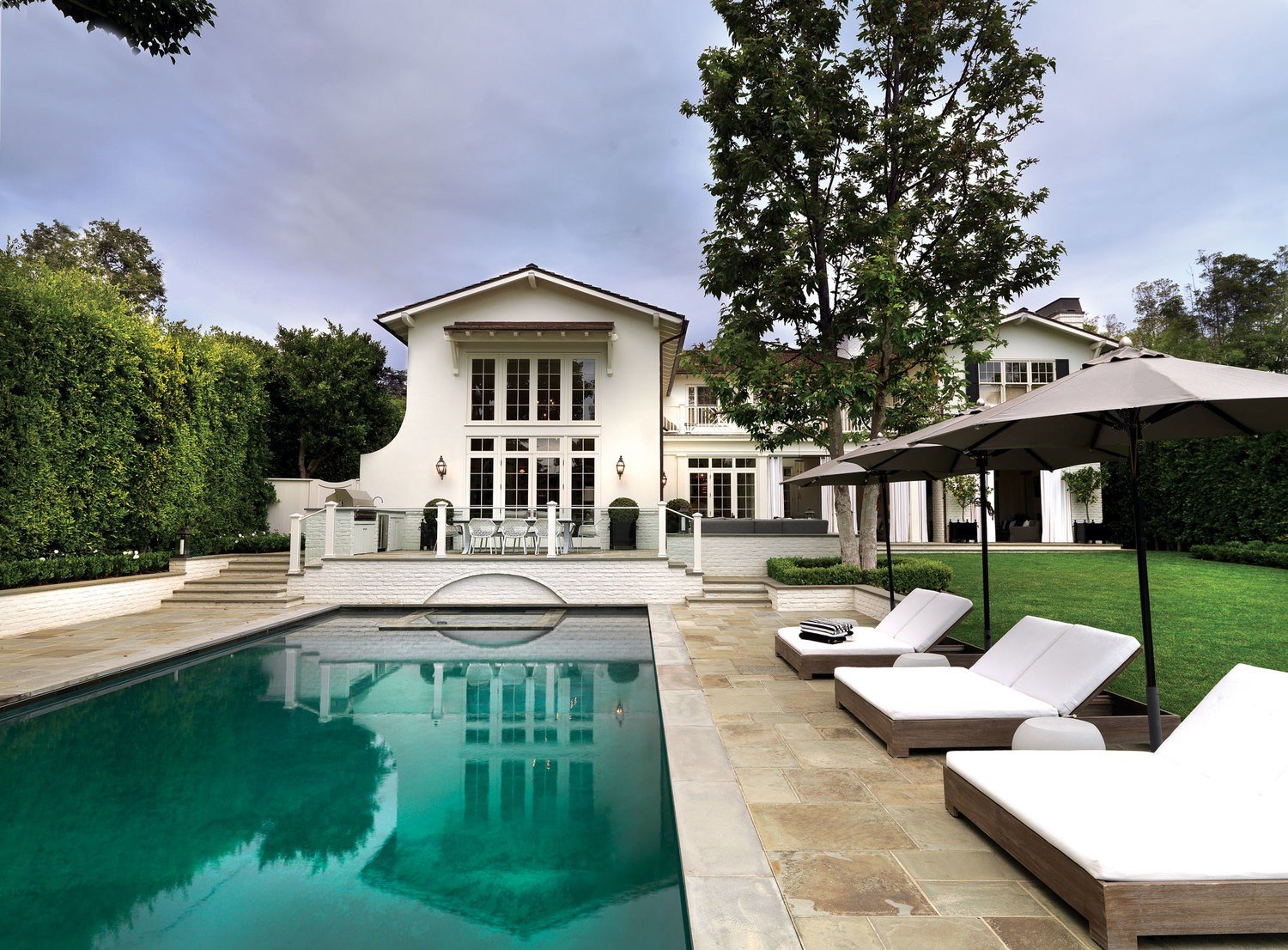 A Brentwood Park house displaying its Classic Monterrey style, large swimming pool and private backyard.