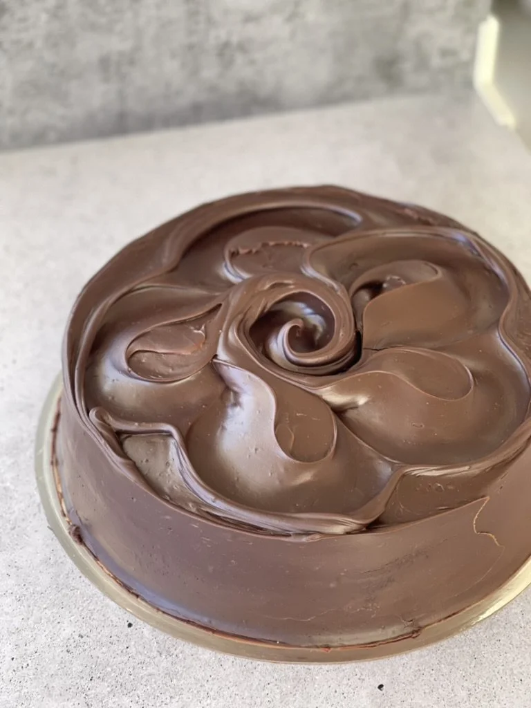 Chocolate ganache spread in a swirl pattern on our iconic Sydney Mud Cake.