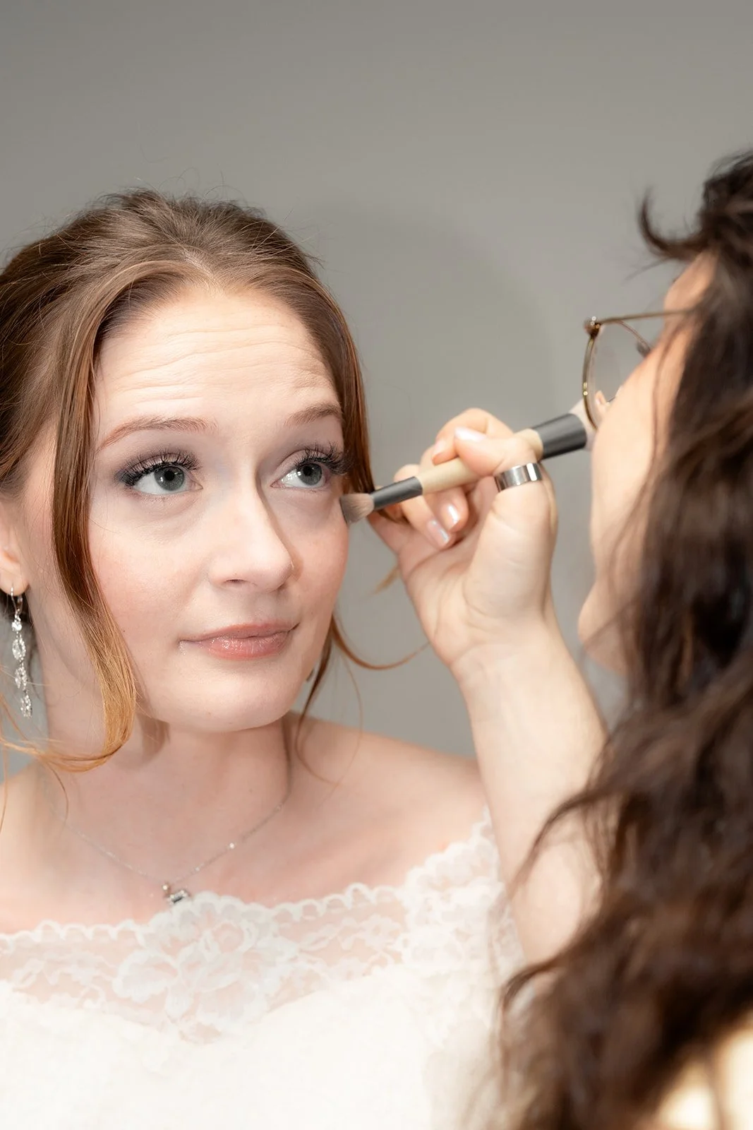 bride finishing makeup for wedding in clarksville, TN