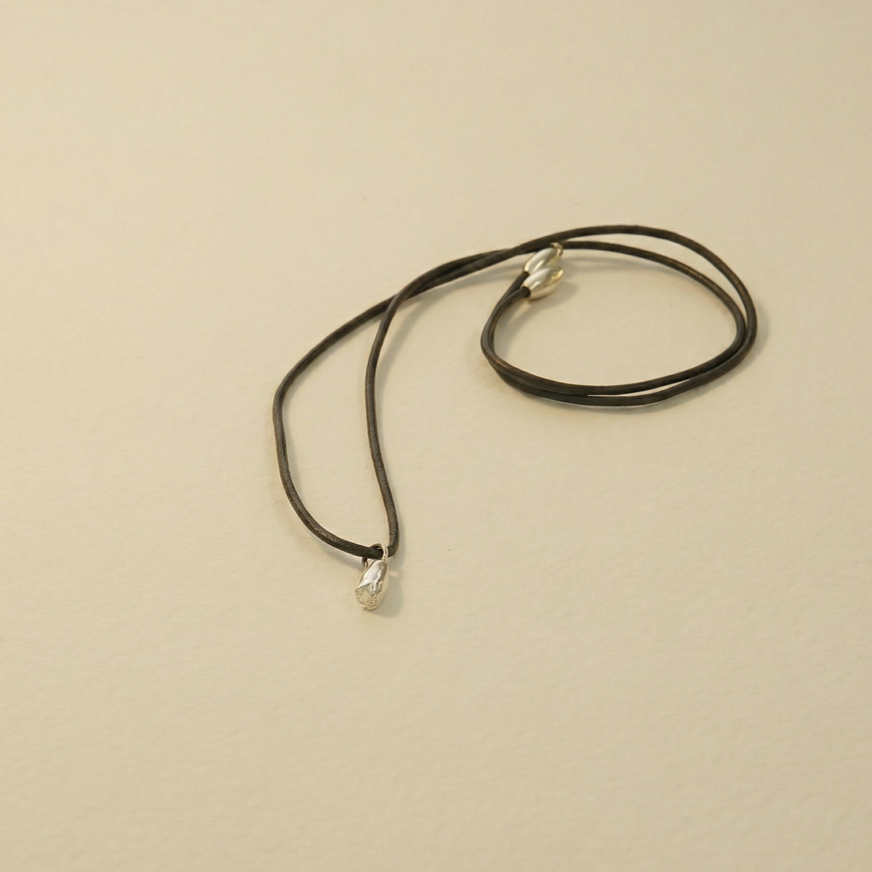 silver lilac flower on leather cord