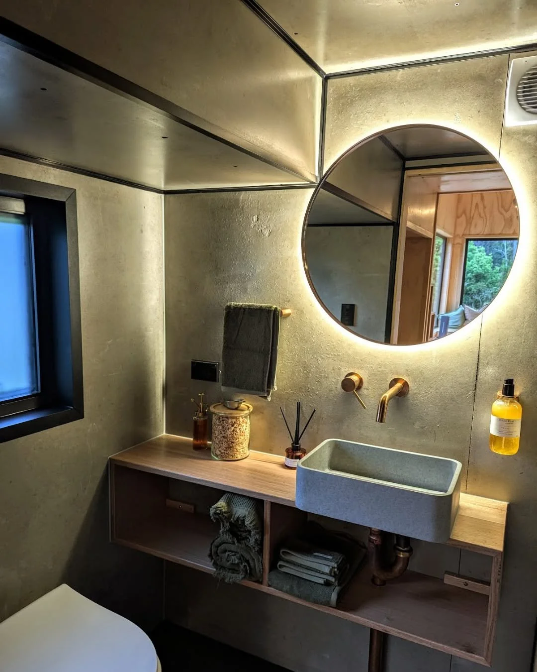 Pull in after dark in winter and the whole place is already glowing.

Low light, warm timber, the backlit mirror, a couple of lamps left on &ndash; it's built to feel like a soft landing after a cold drive up the lane. Off-grid, but you'd never guess