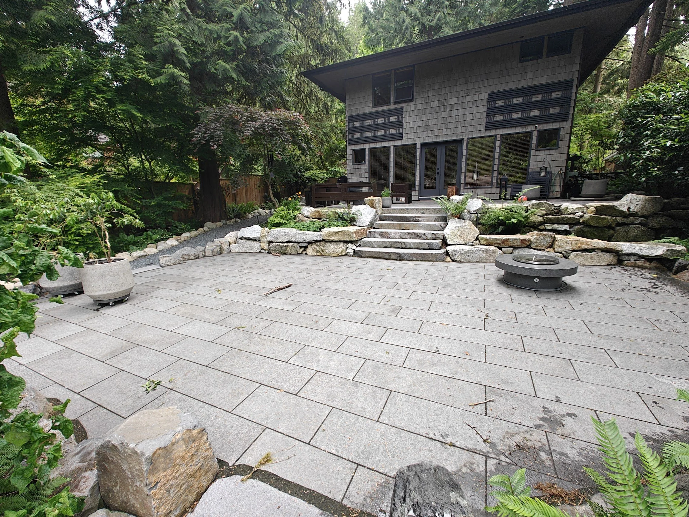 Premium North Vancouver patio featuring high-end natural stone paving in a coastal outdoor setting