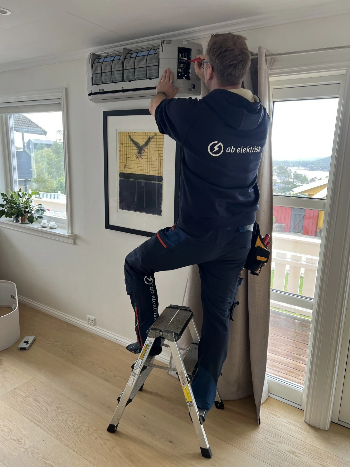 Montør som skrur på en varmepumpe