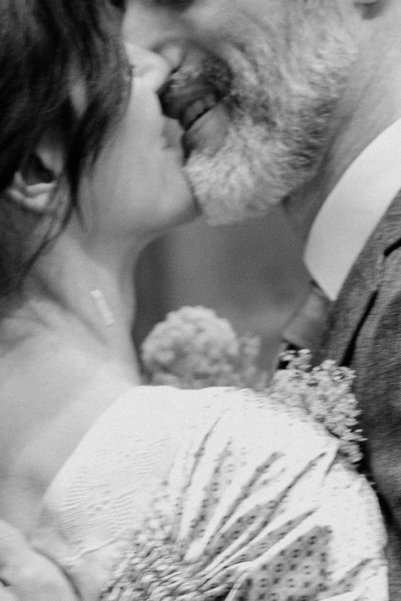 A black and white photograph of a woman and a man in a close, intimate moment about to kiss.